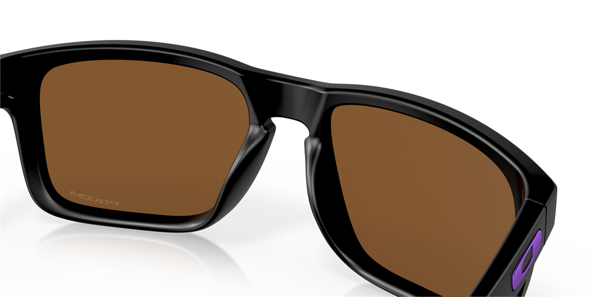 Black sunglasses with brown lenses on a reflective surface