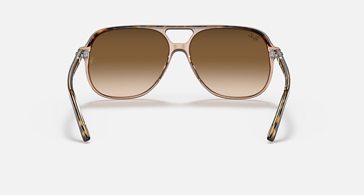 Aviator sunglasses with brown gradient lenses on a light gray background