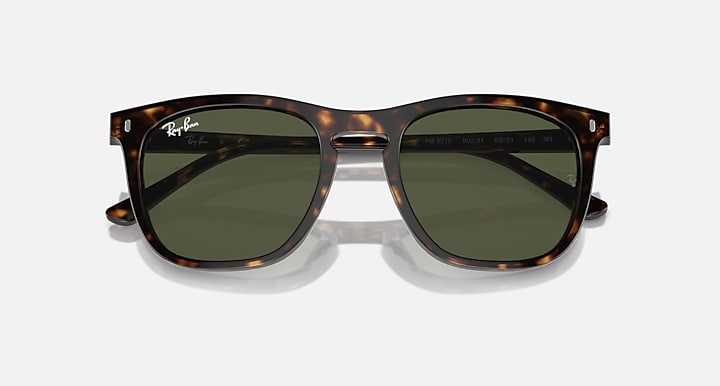 Tortoiseshell sunglasses with green lenses on a white background