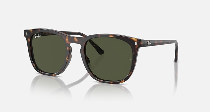 Sunglasses with tortoiseshell frame and green lenses on a white background