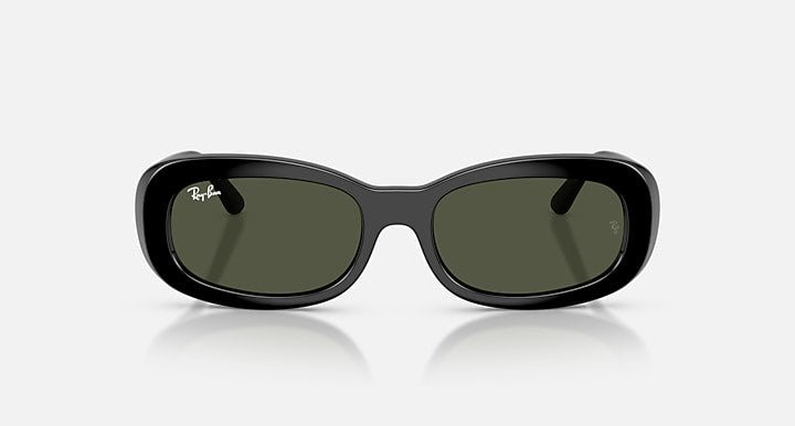 Black sunglasses with green lenses on a white background