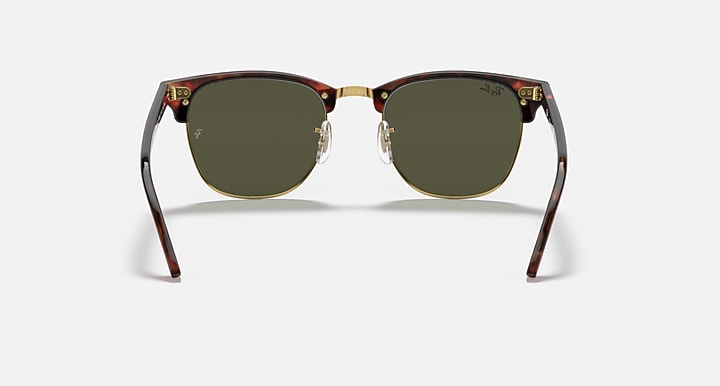 Sunglasses with tortoiseshell frame and green lenses on a white background
