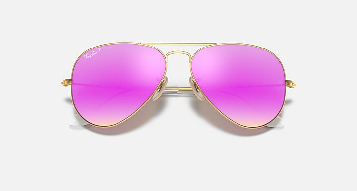 Aviator sunglasses with pink lenses and gold frames on a white background