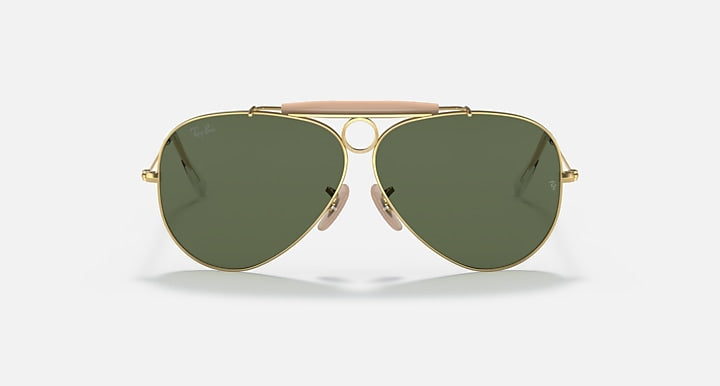 Aviator sunglasses with gold frame and green lenses on a white background