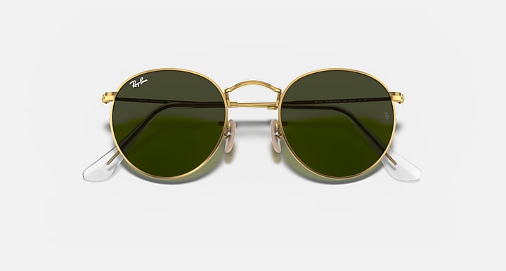 Gold-framed sunglasses with green lenses on a white background