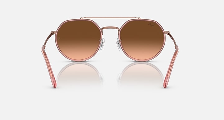 Sunglasses with rose gold frame and brown gradient lenses on a white background