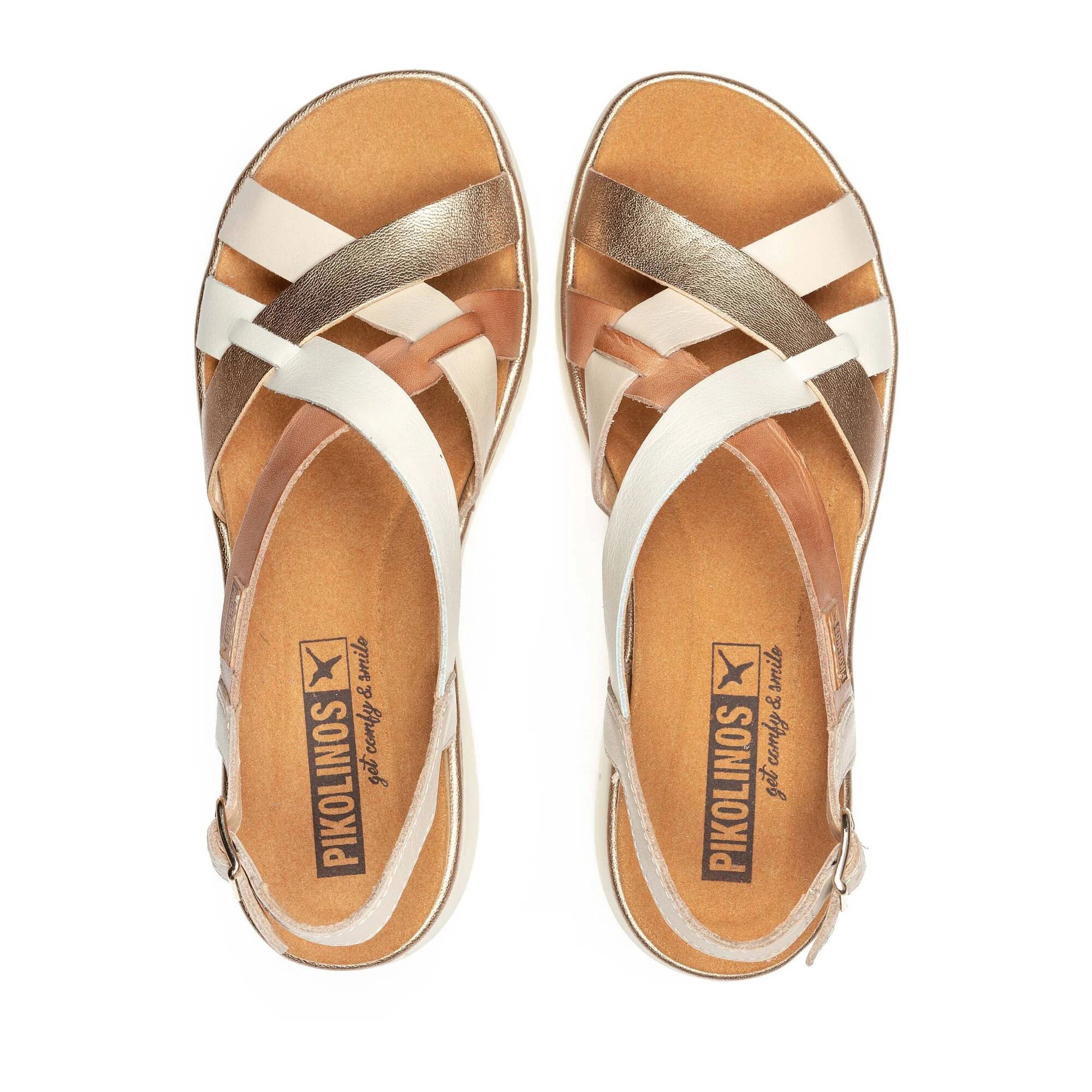 Pair of tan and white sandals with metallic accents on a white background