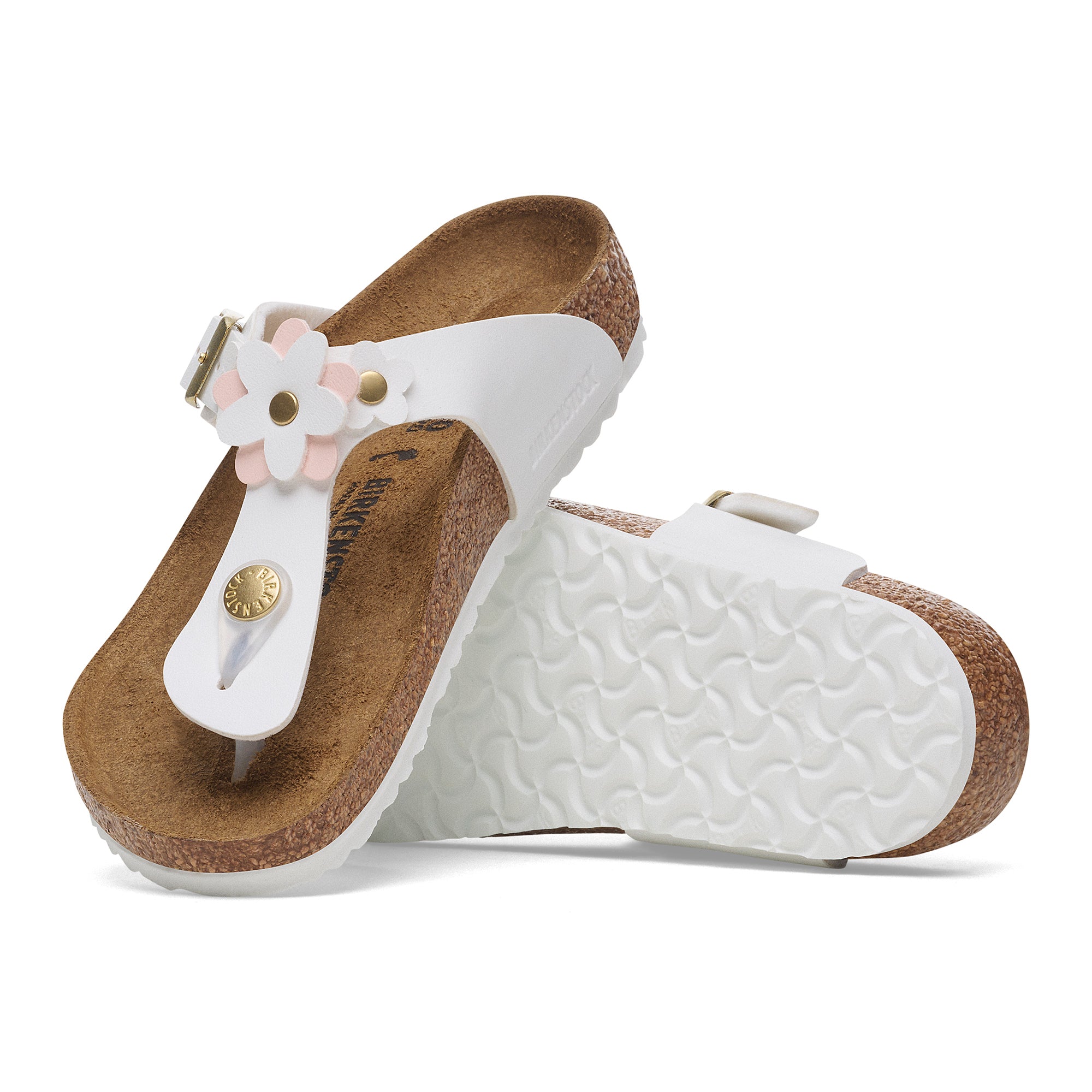 White sandals with brown soles and floral design on a white background
