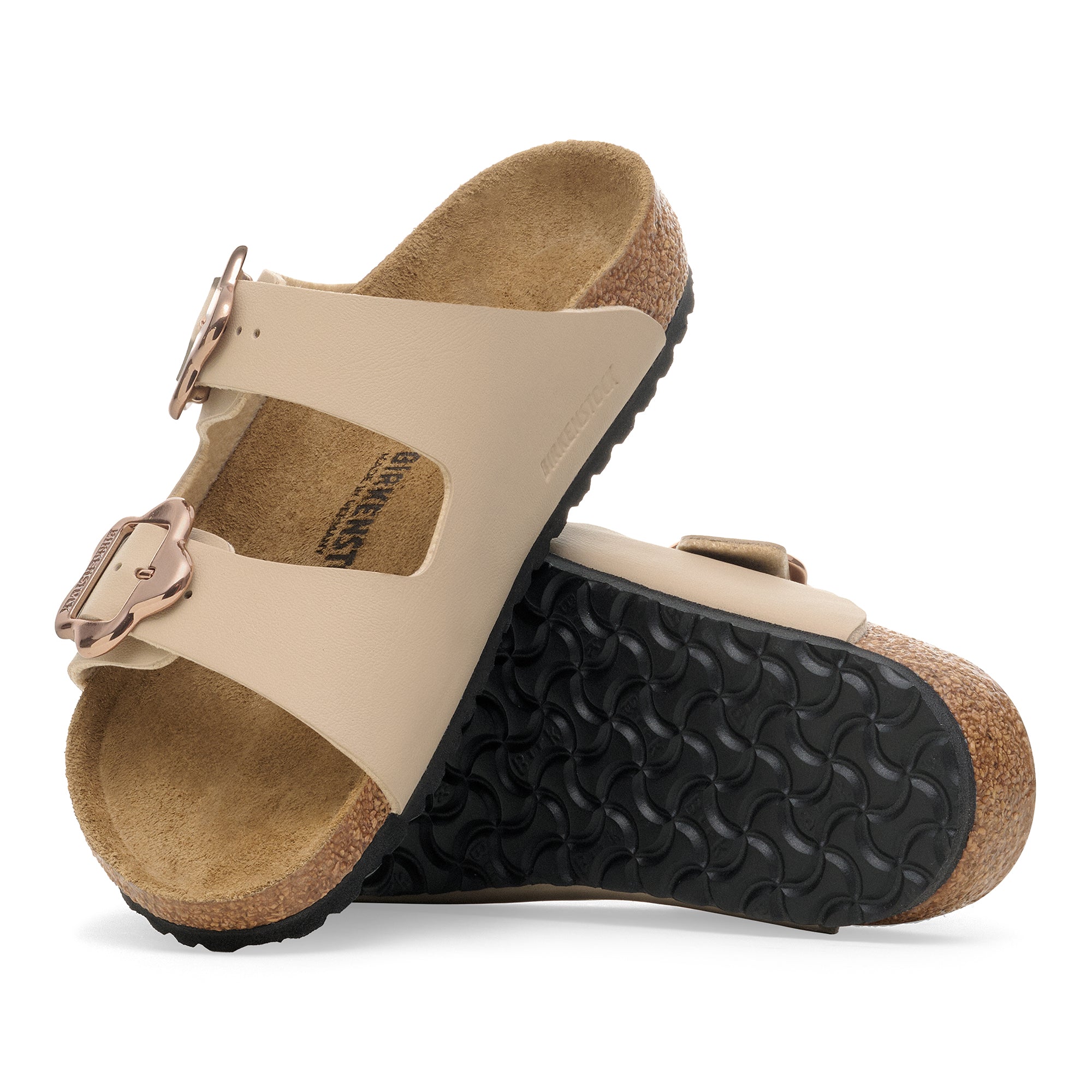 Pair of beige sandals with cork soles on a white background