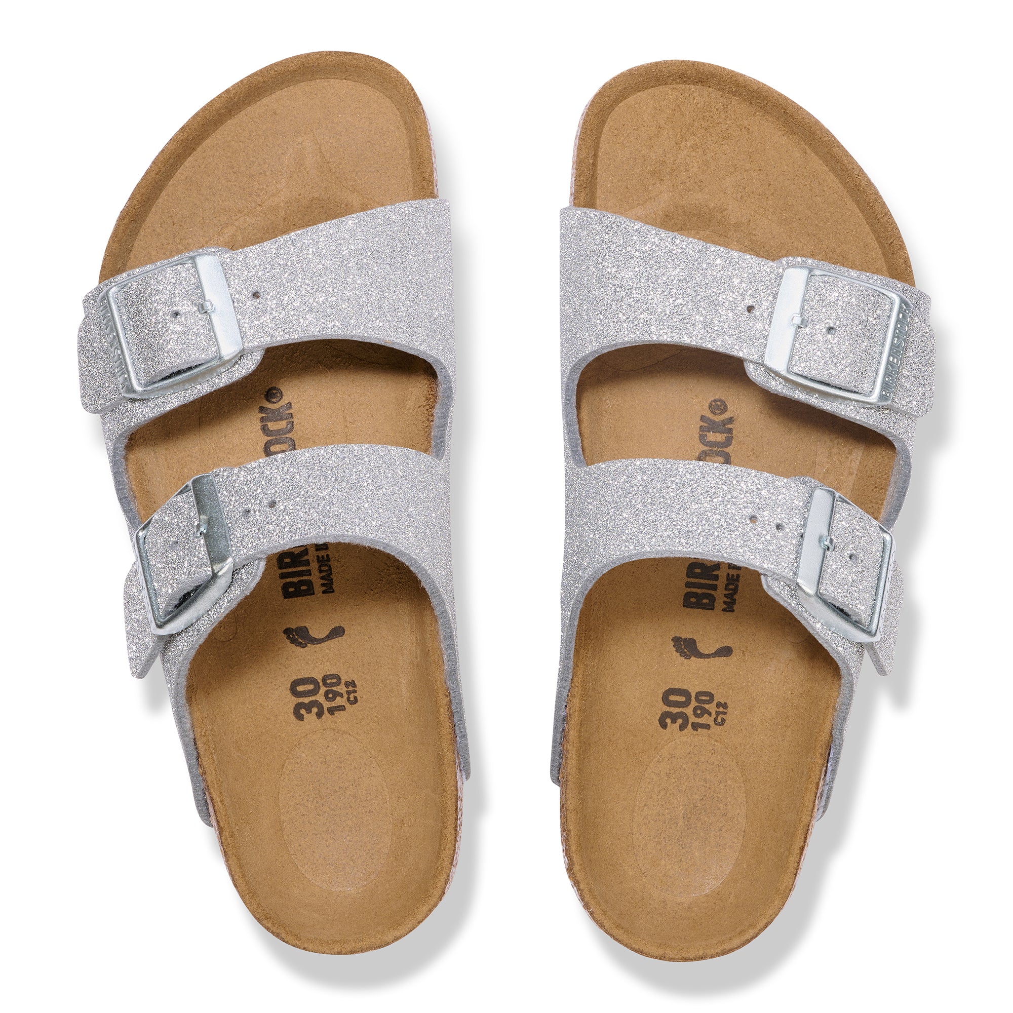 Pair of silver glitter sandals with brown soles on a white background
