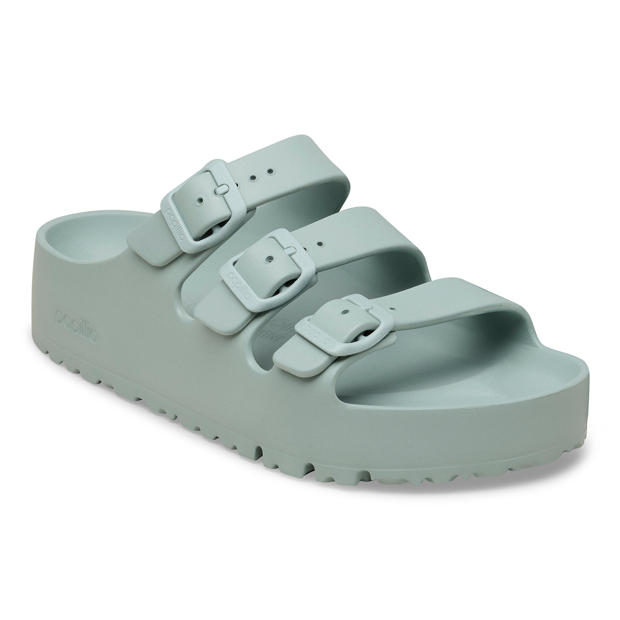 Light green sandal with double buckle strap on a white background