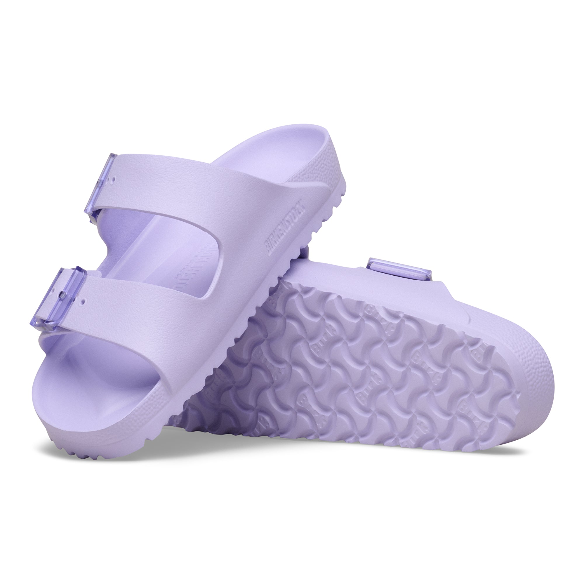 Pair of light purple sandals with textured sole on a white background