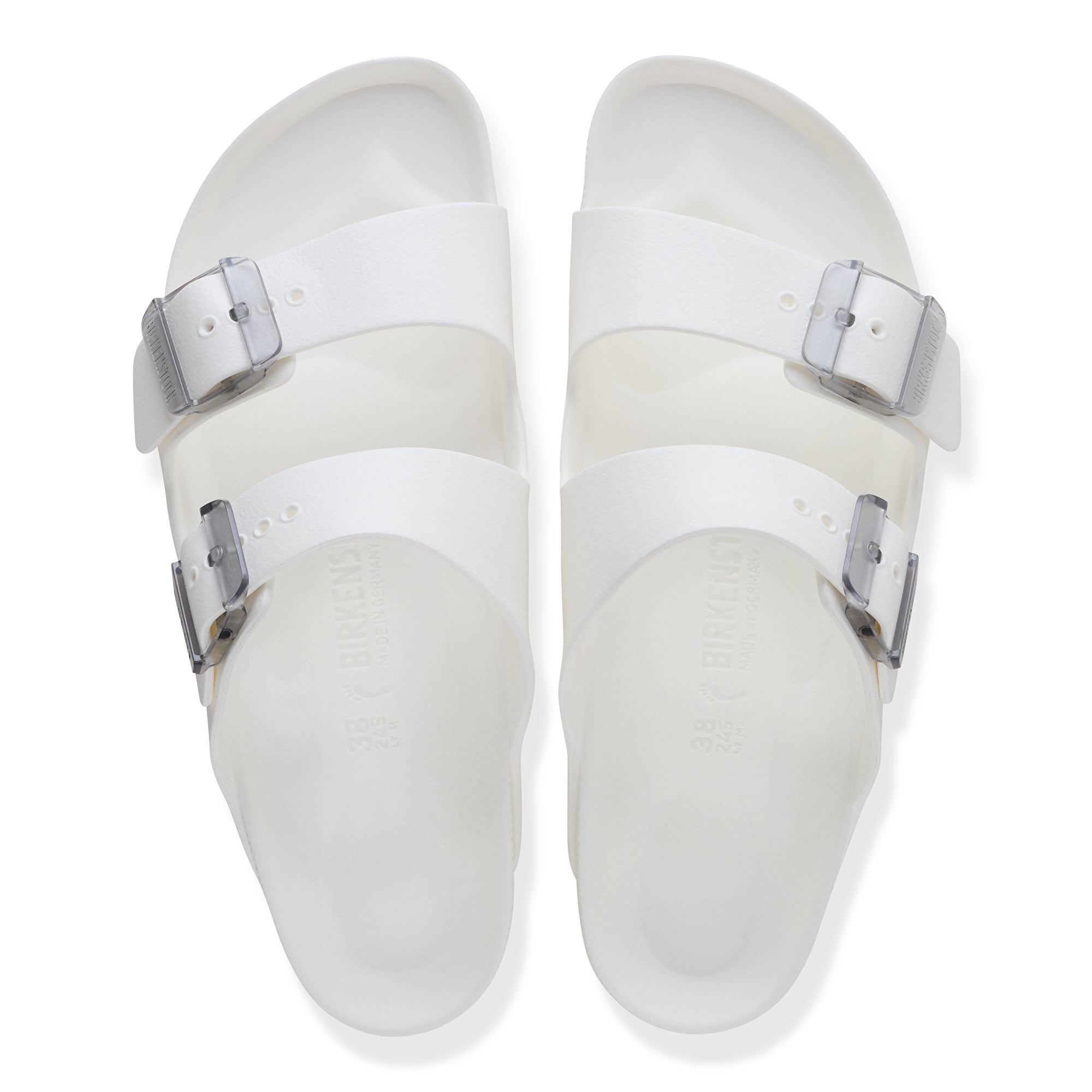 Pair of white sandals with silver buckles on a white background
