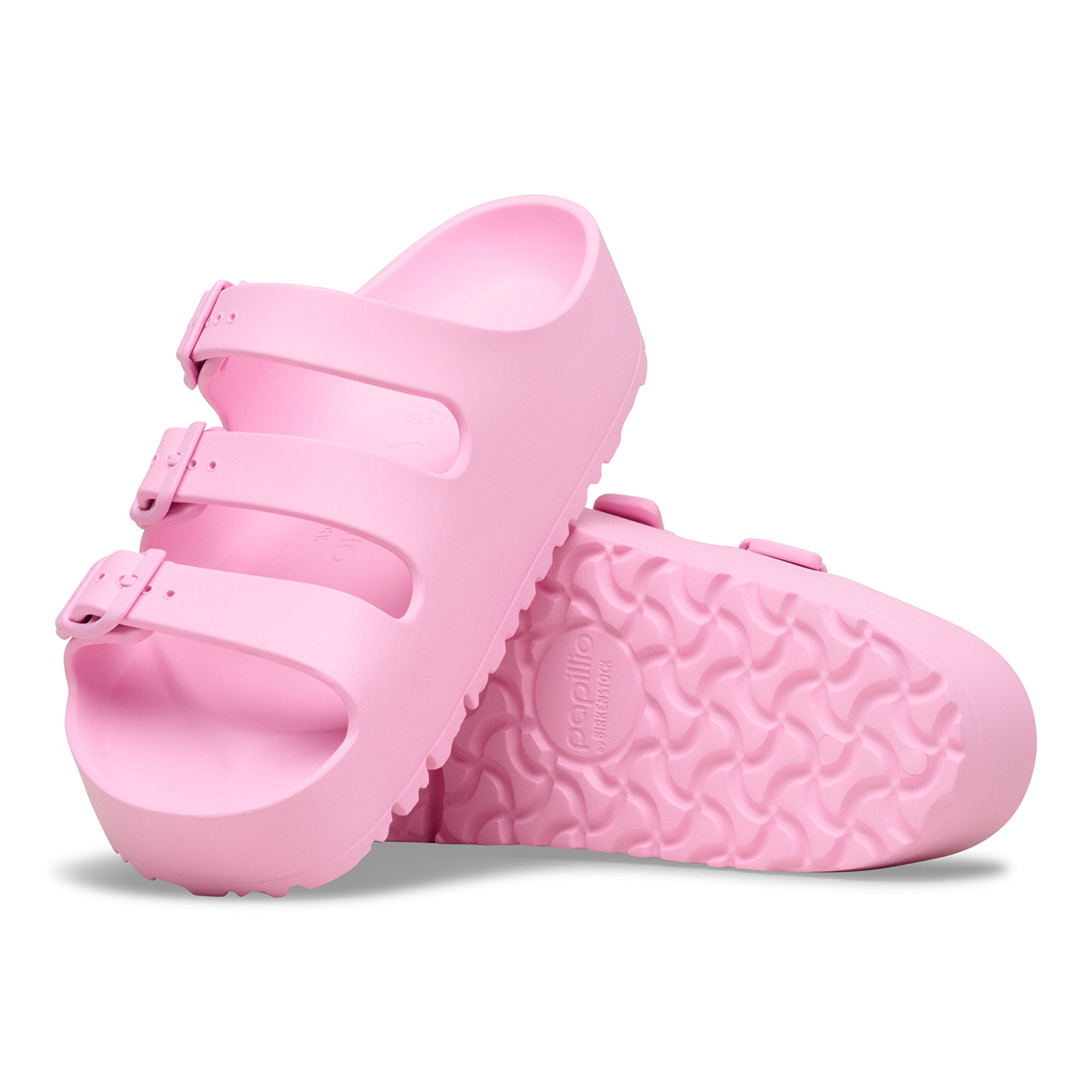 Pink children's shoes with textured sole on a white background