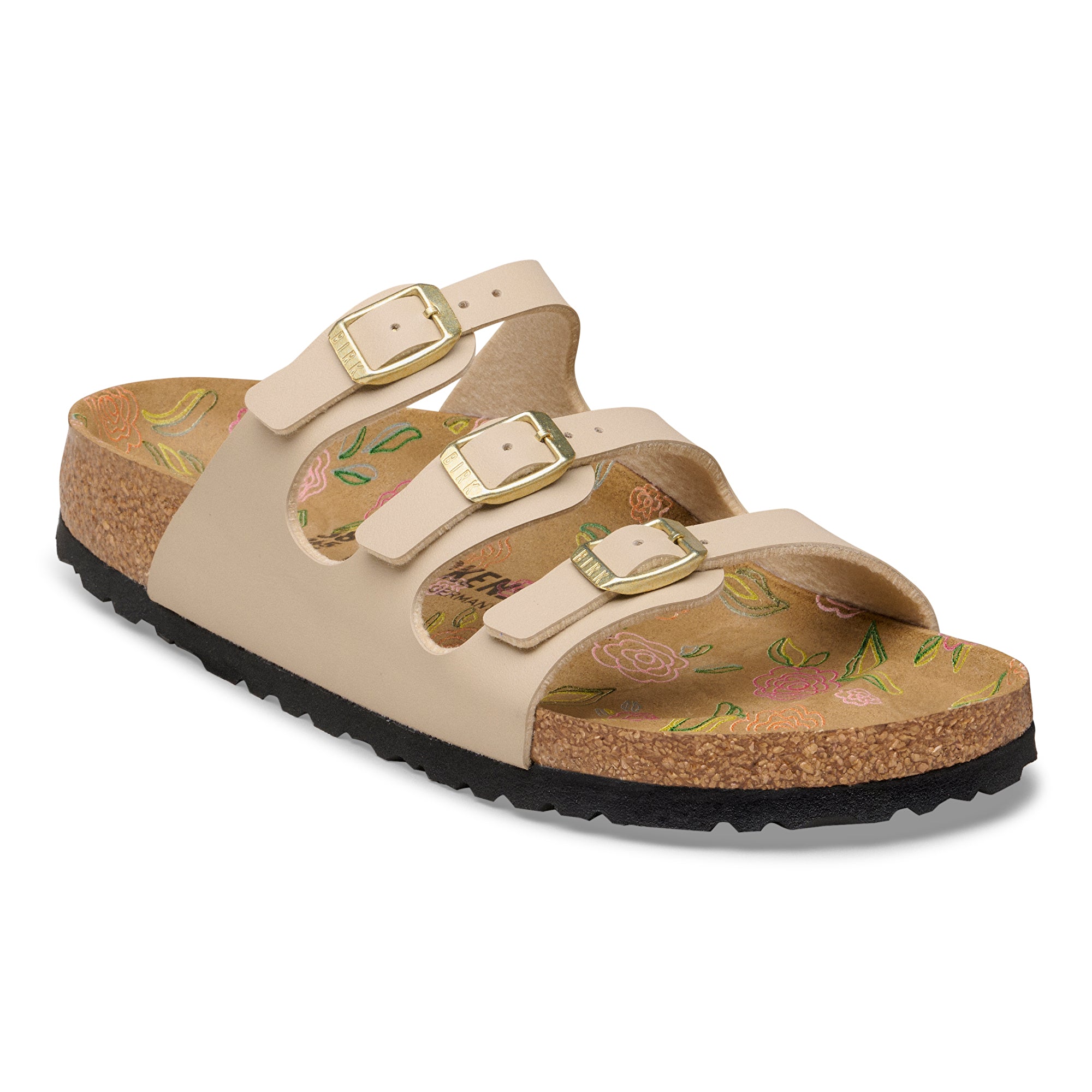 Beige sandal with floral pattern and gold buckles on a white background