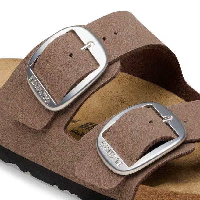 Brown sandals with silver buckles on a white background