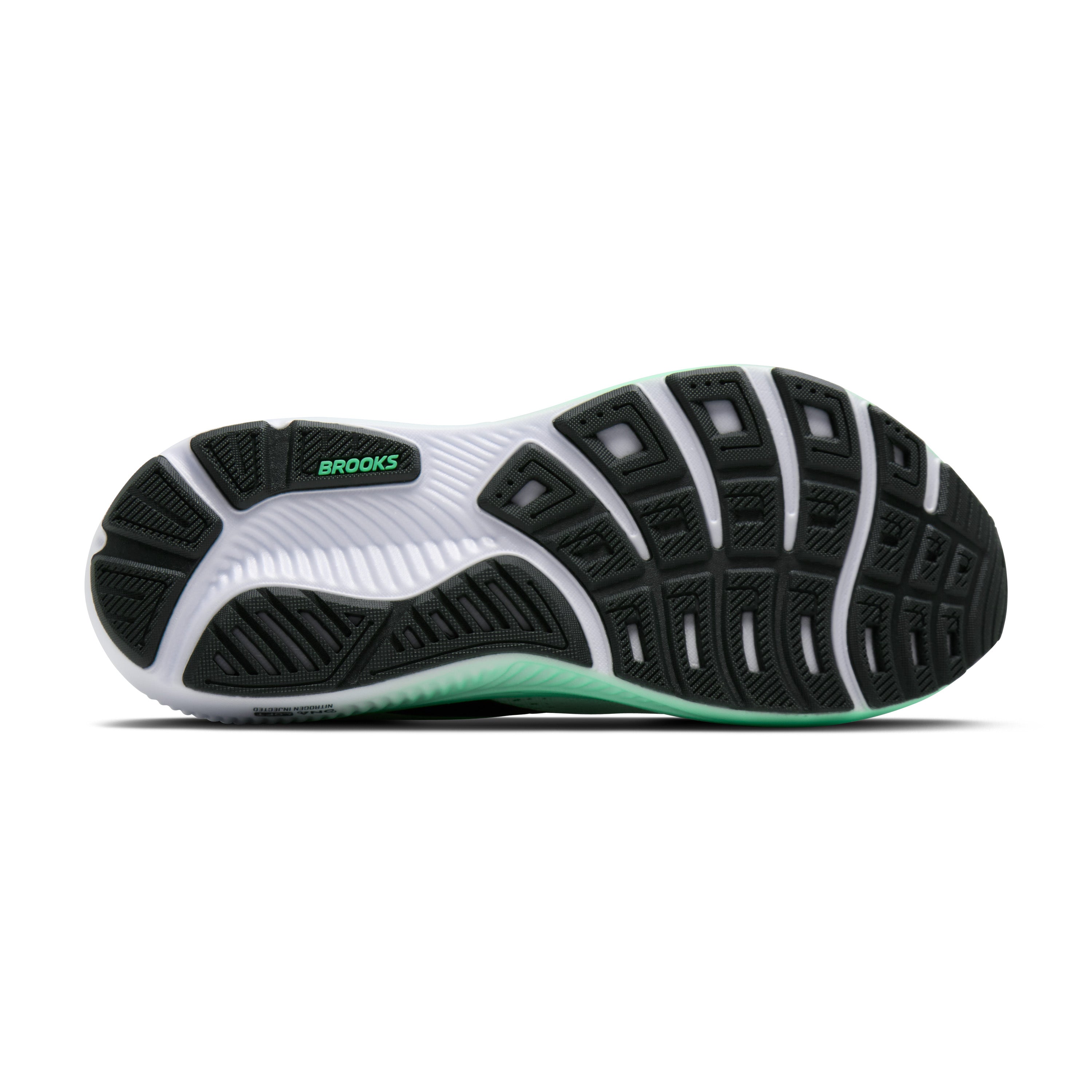 Black and white running shoe with green sole on a white background