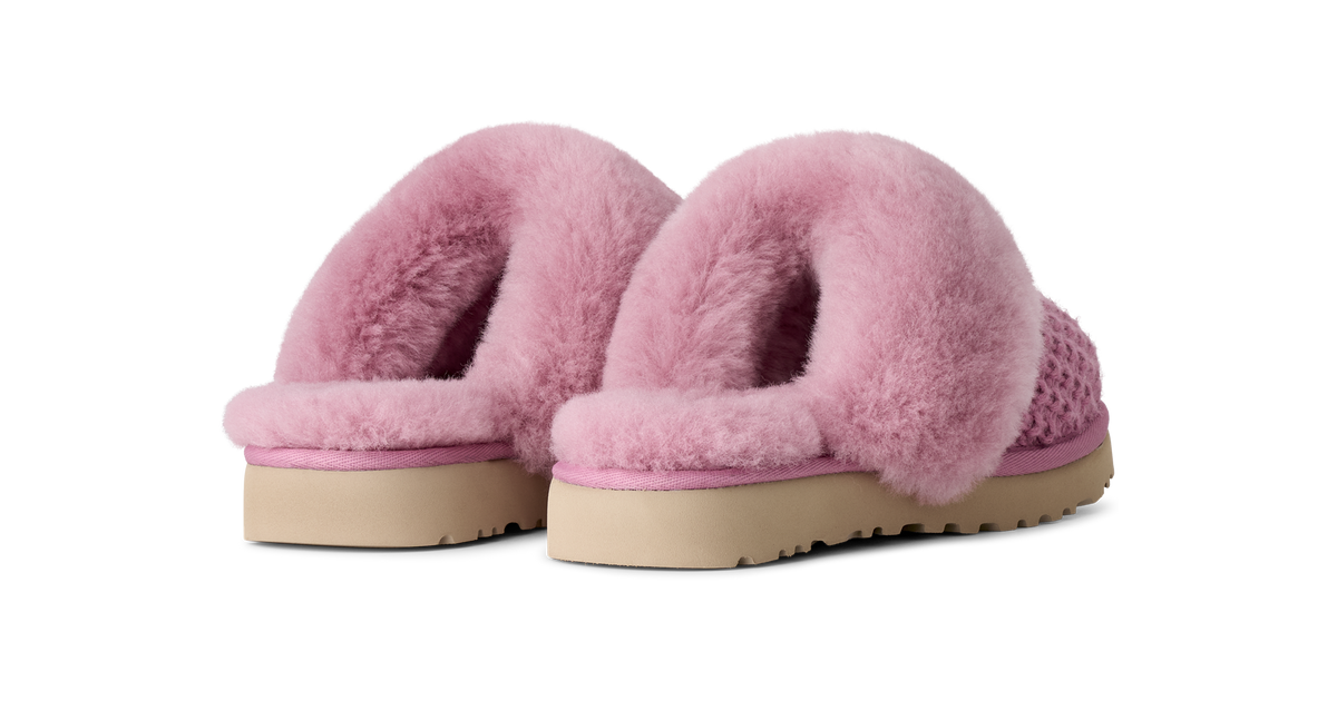 A pair of pink fuzzy slip-on slippers with a textured knit base and beige soles, shown against a plain white background.