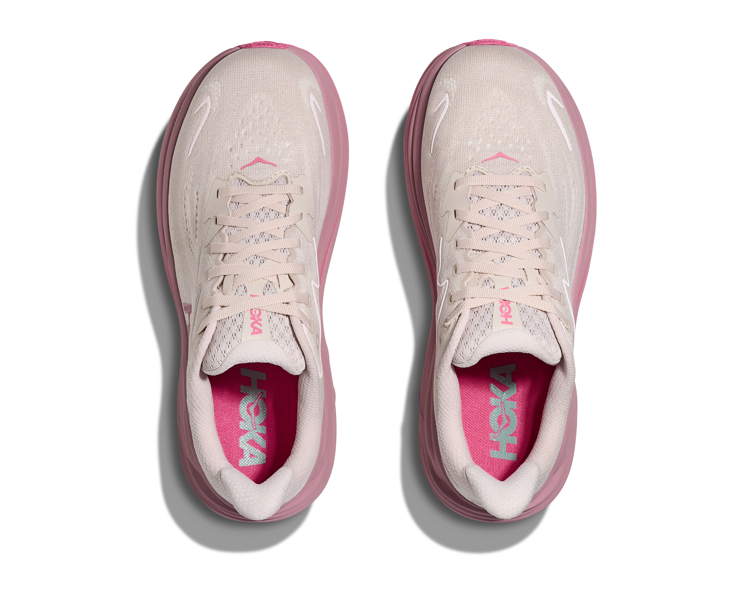 Pink and white Hoka running shoes on a white background