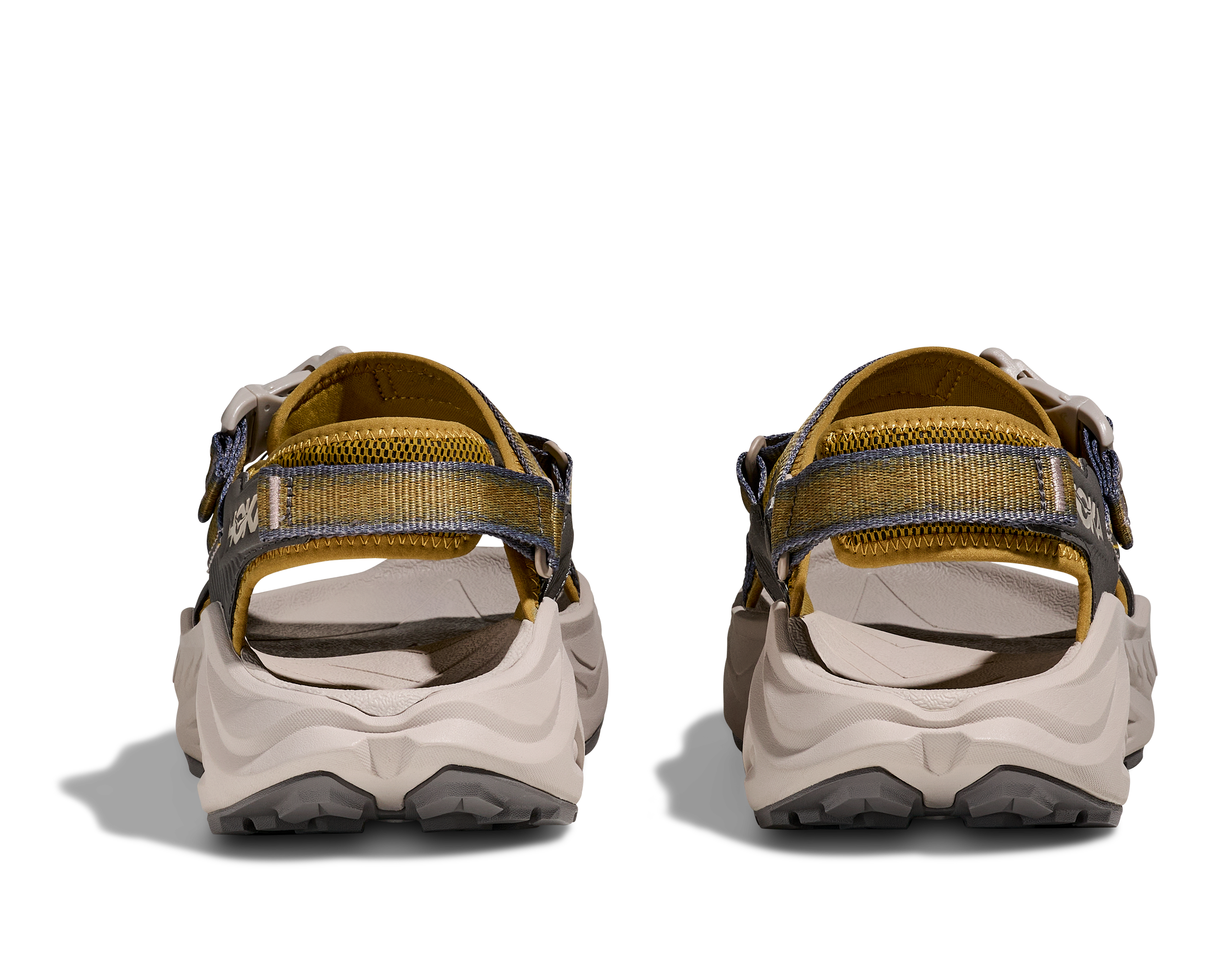 Pair of beige and brown sandals with gray soles on a white background