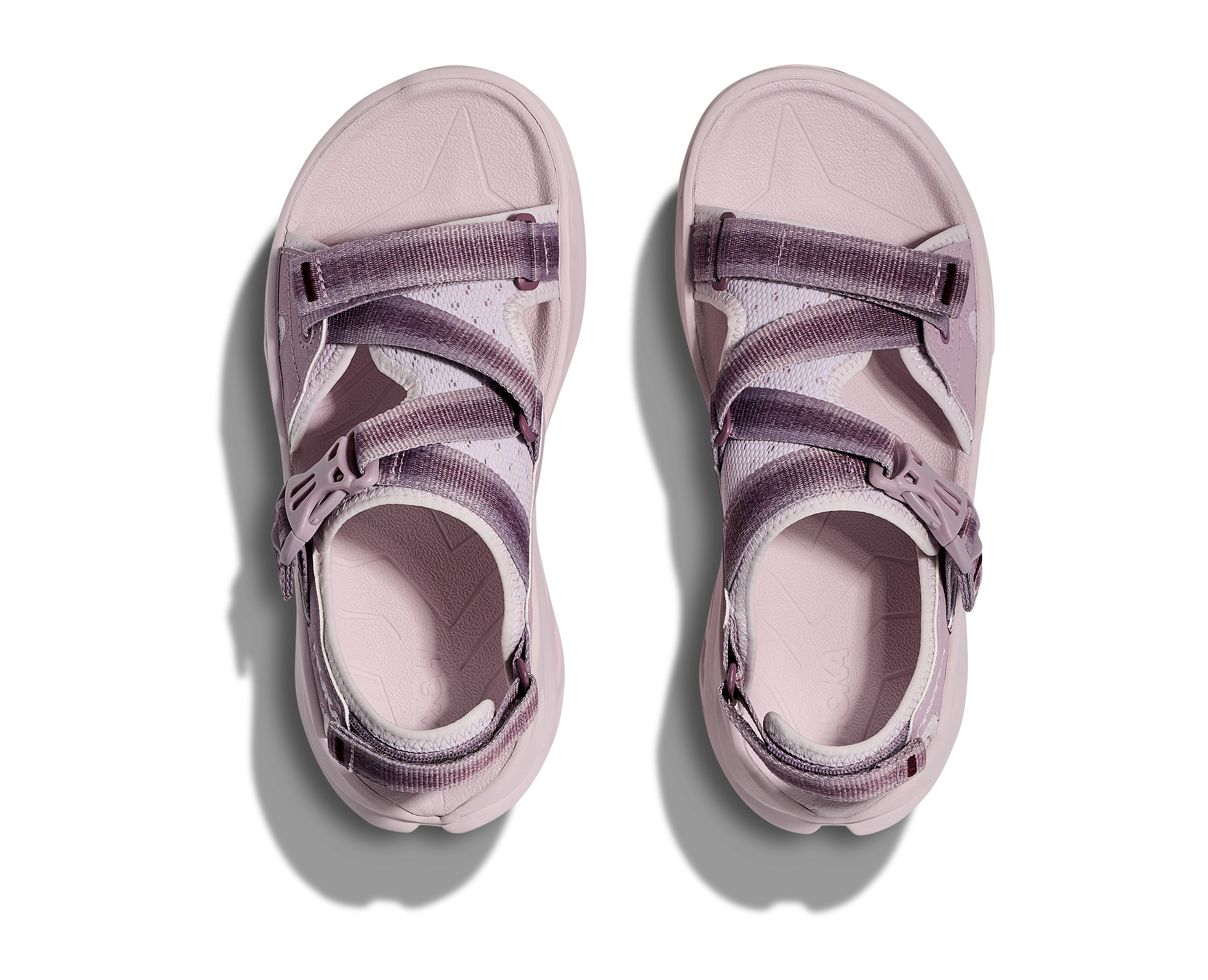 Pair of pink sandals with purple straps on a white background