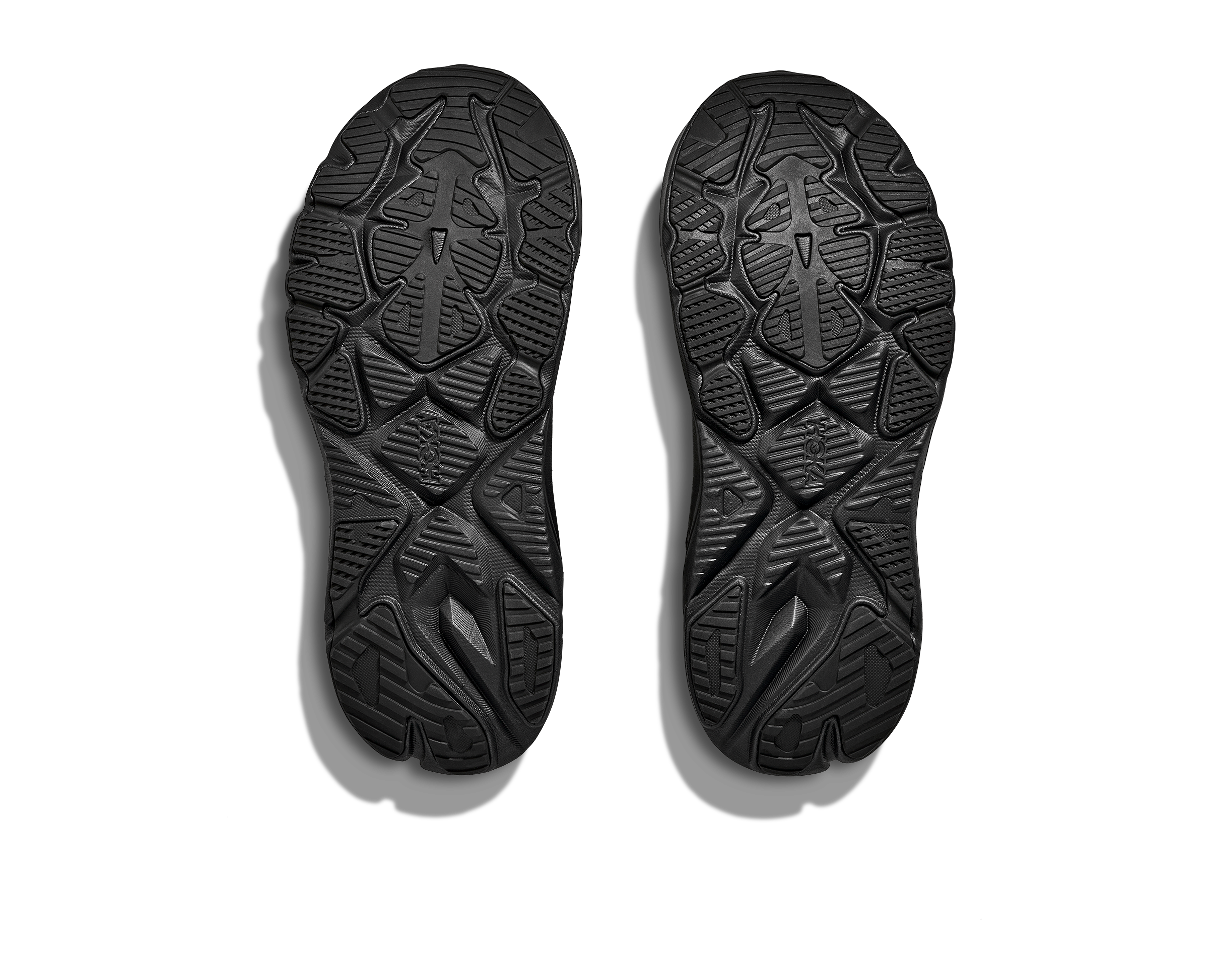 Black shoe soles with tread pattern on a white background