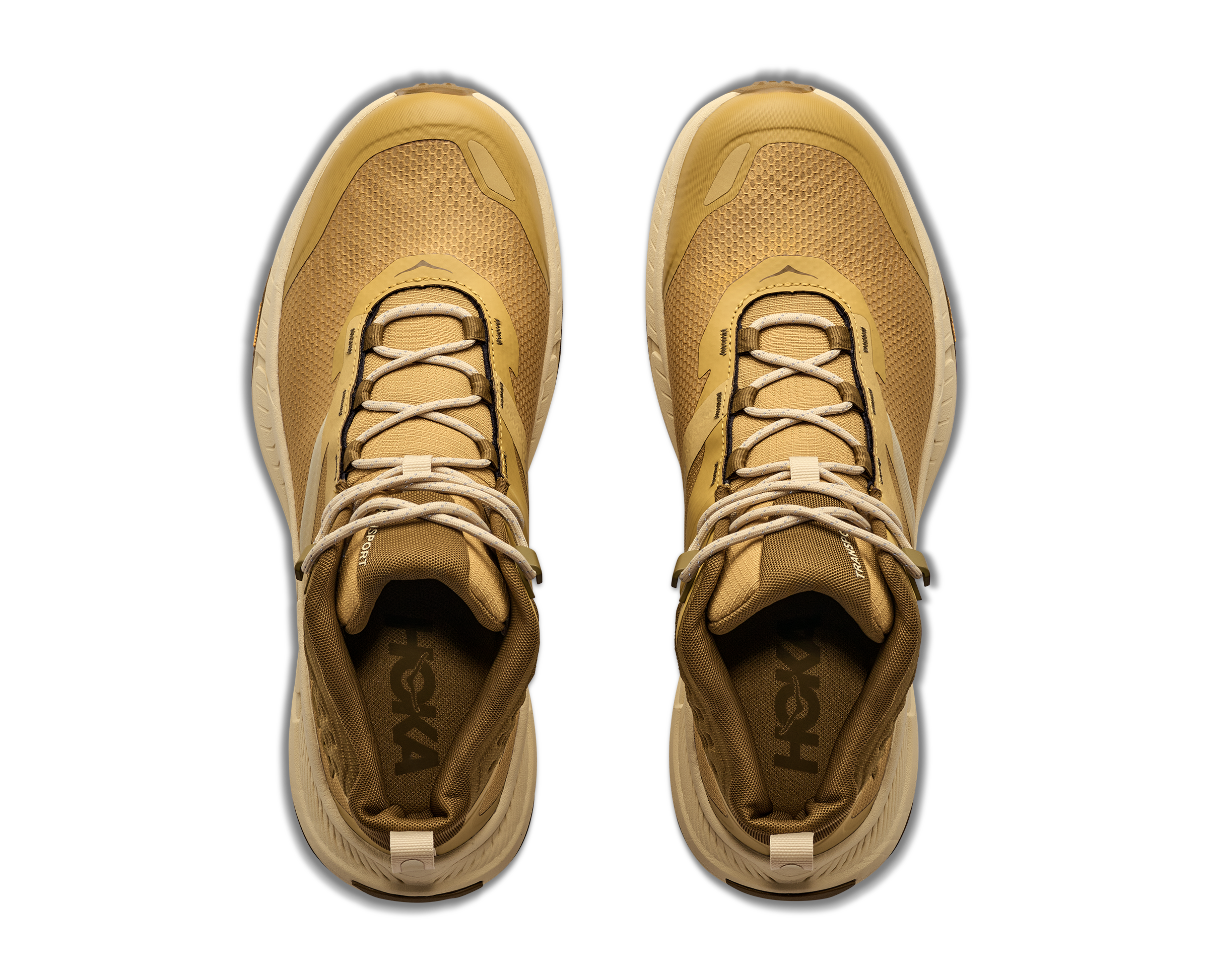 A pair of tan and beige HOKA trail running shoes shown from a top-down view on a white background.