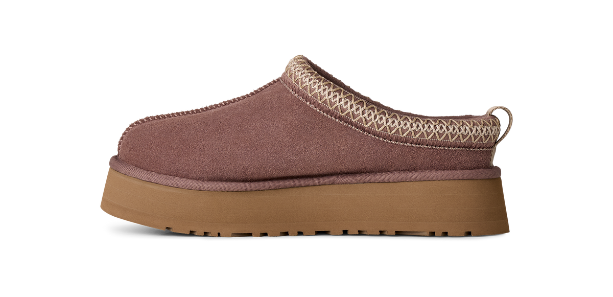 A single slip-on clog-style mule shoe shown in side profile on a plain white background. The upper is a muted dusty mauve-brown suede-like material with a beige geometric woven trim around the collar, and it has a thick tan gum sole.