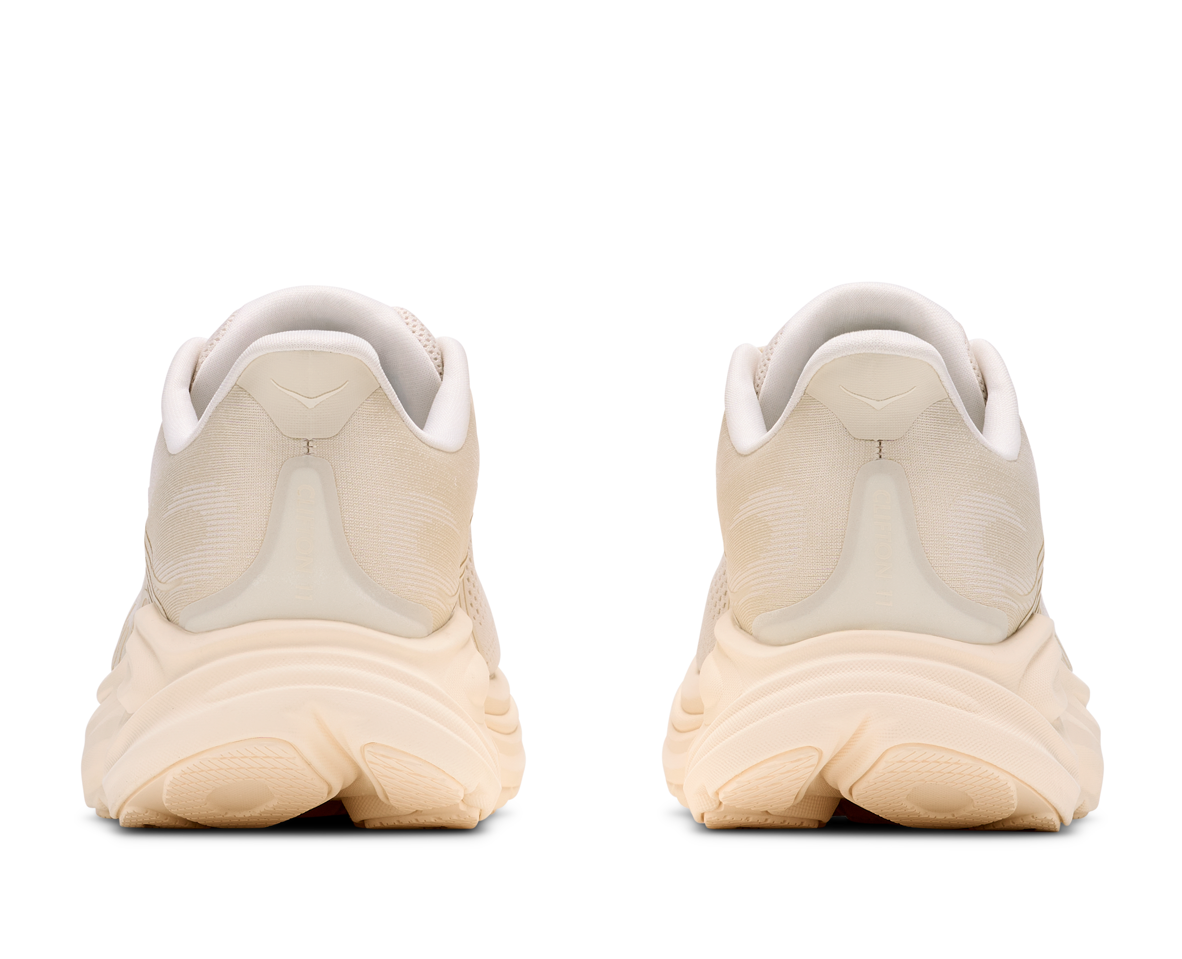 Beige running shoes with white soles on a white background
