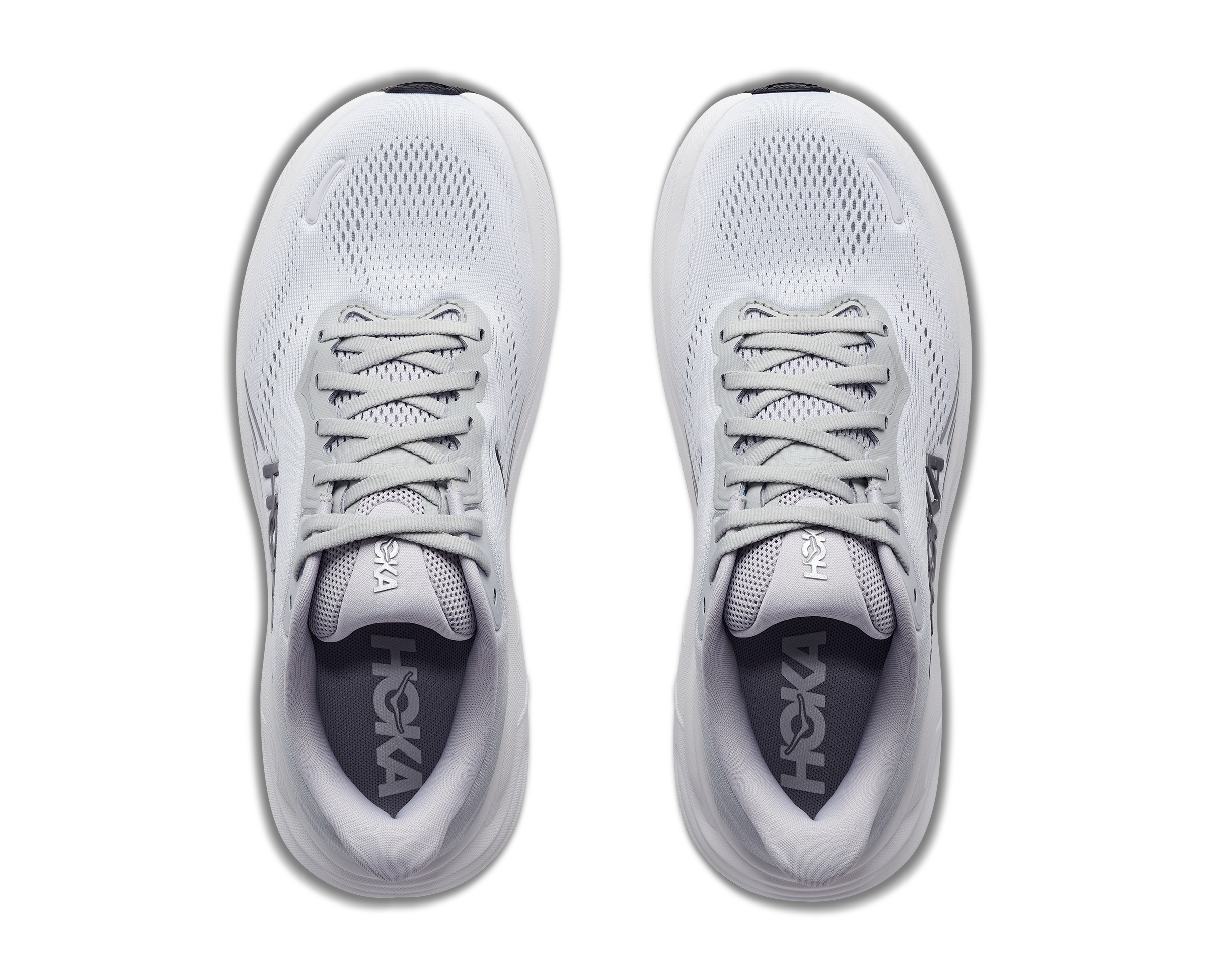 Pair of white running shoes with 'hoka' branding on a white background