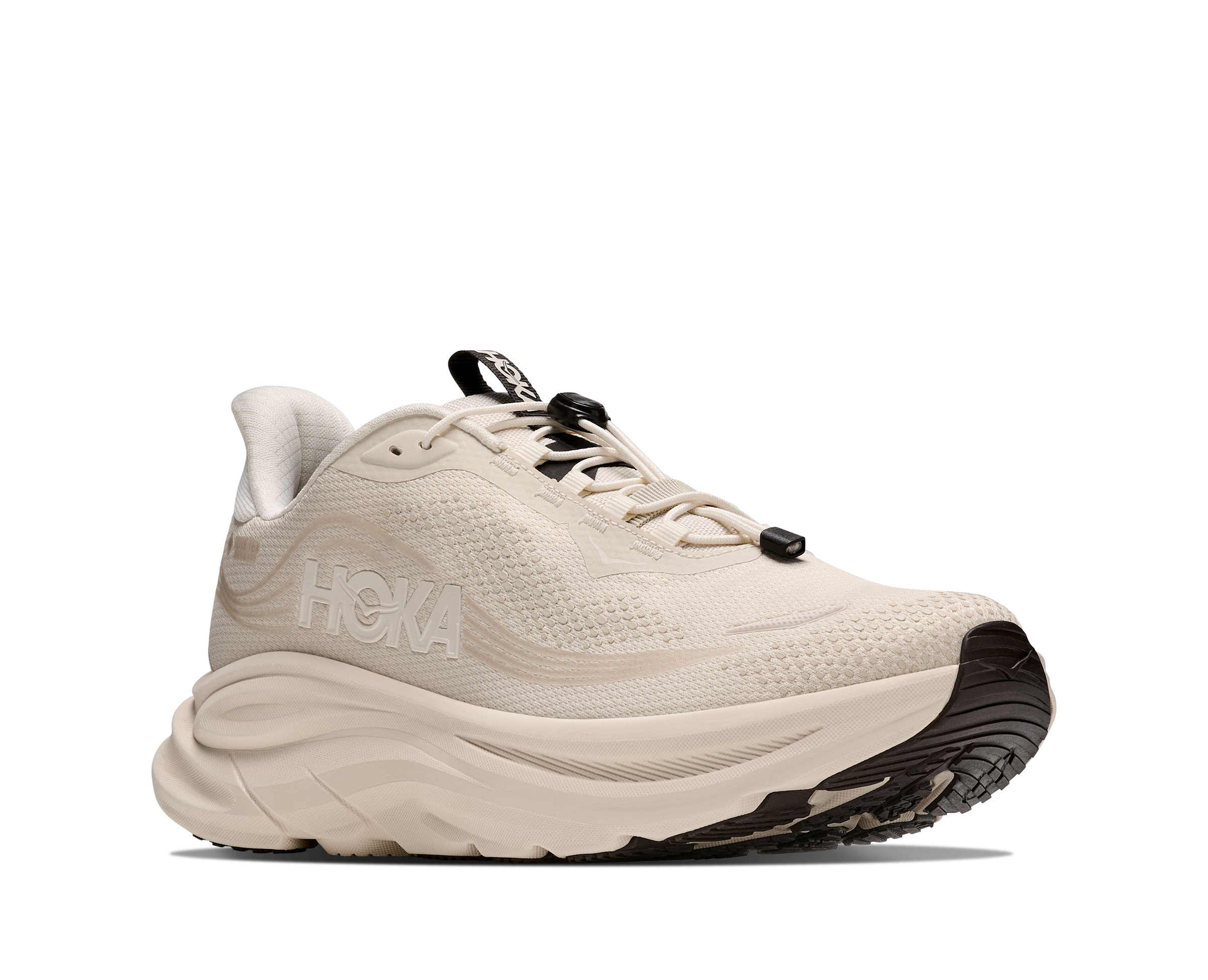 Beige running shoe with black sole on a white background