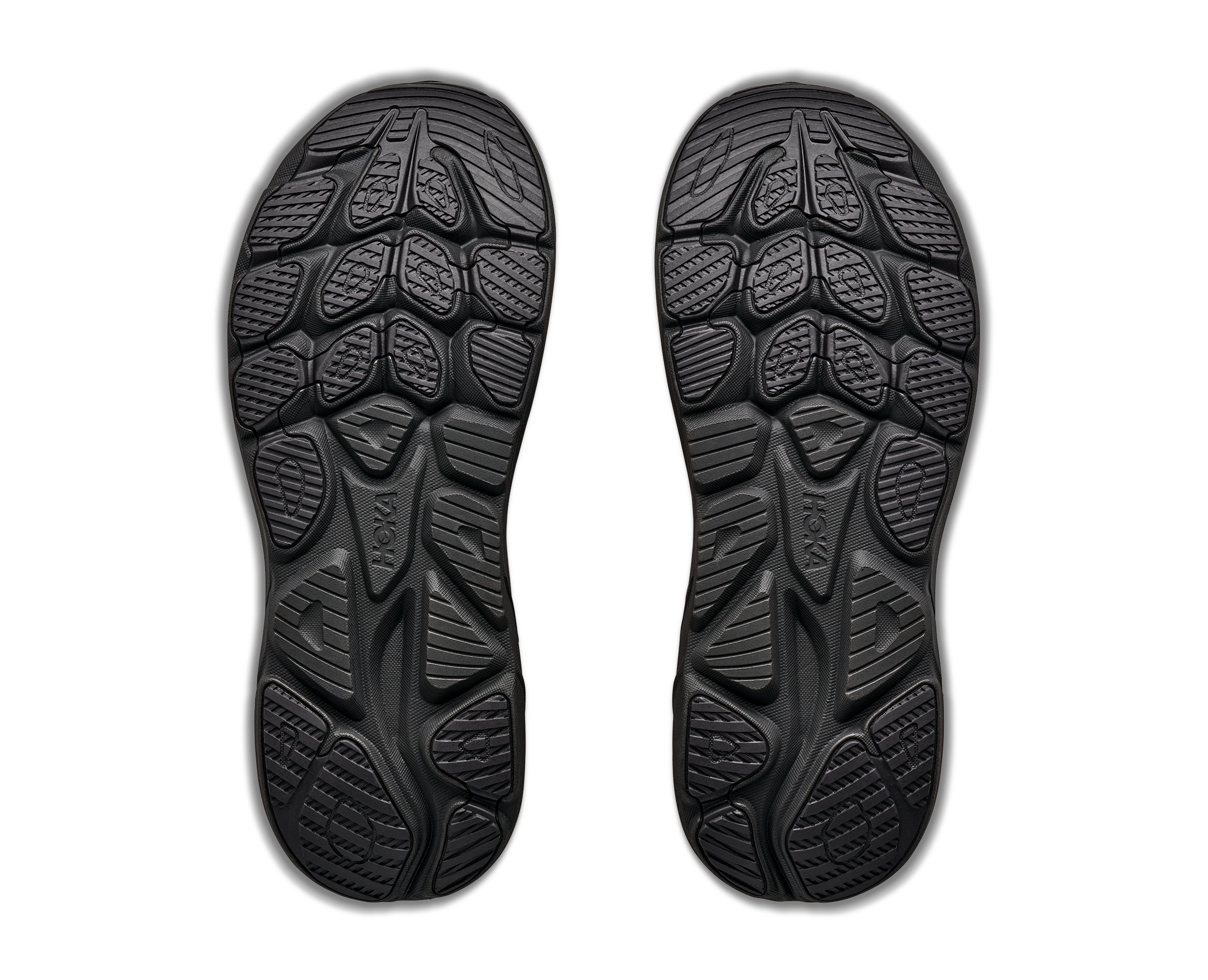 Black shoe soles with tread pattern on a white background