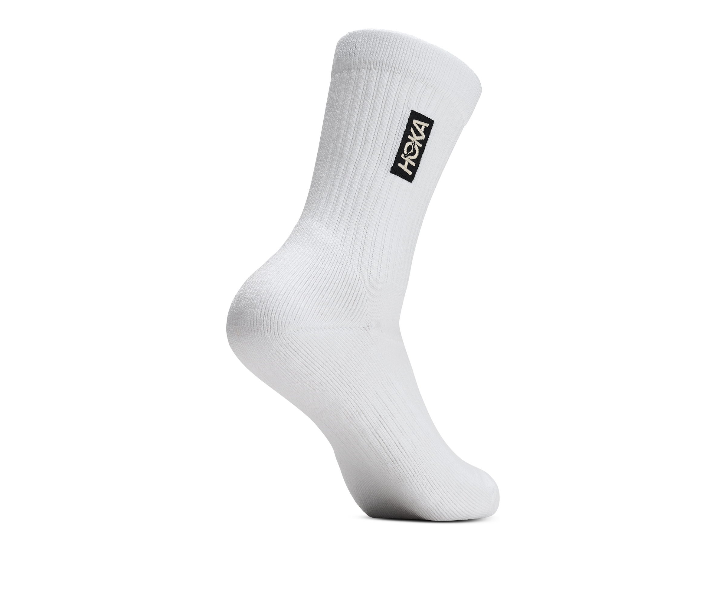 A single white crew sock shown on a white background, featuring a black rectangular HOKA logo patch on the upper cuff.