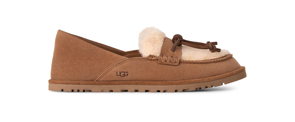 A single UGG slip-on moccasin-style shoe in tan suede with a fluffy cream shearling lining and a matching tan sole, shown in side profile on a white background.