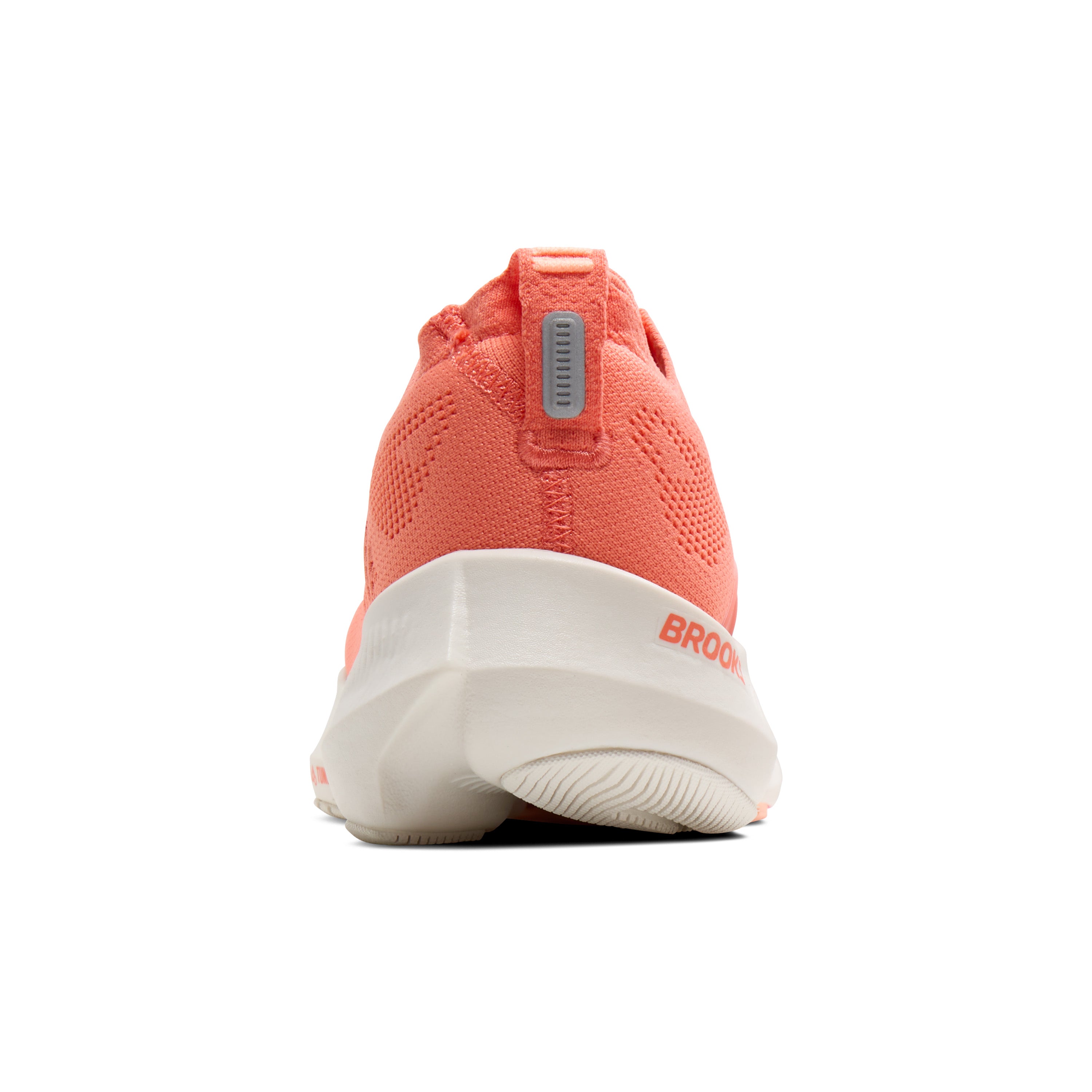 Coral running shoe with white sole on a white background