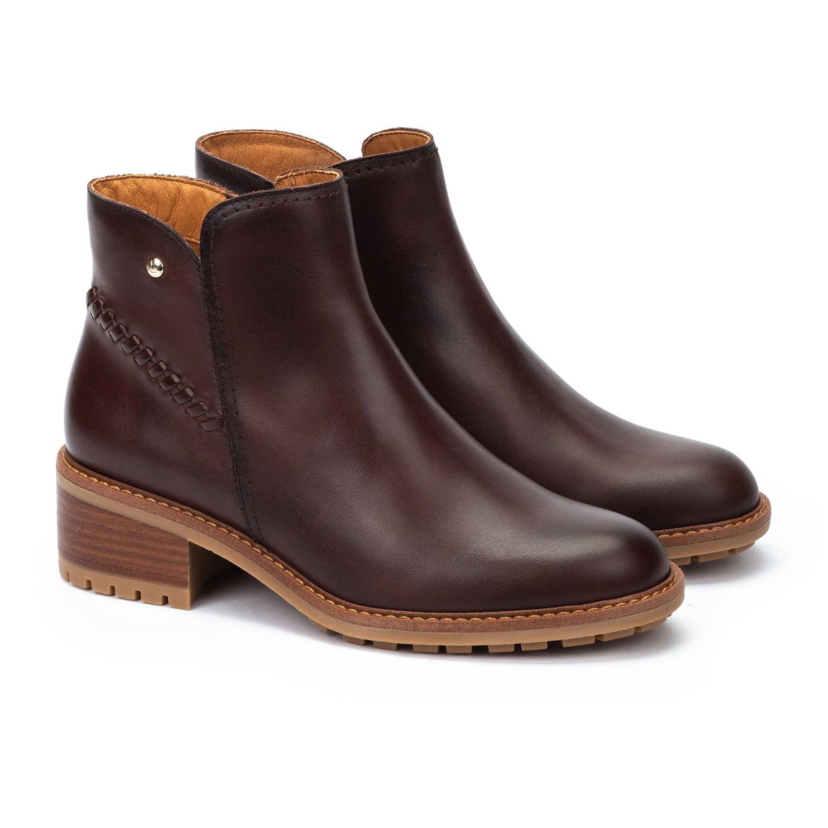 Pair of brown leather ankle boots on a white background