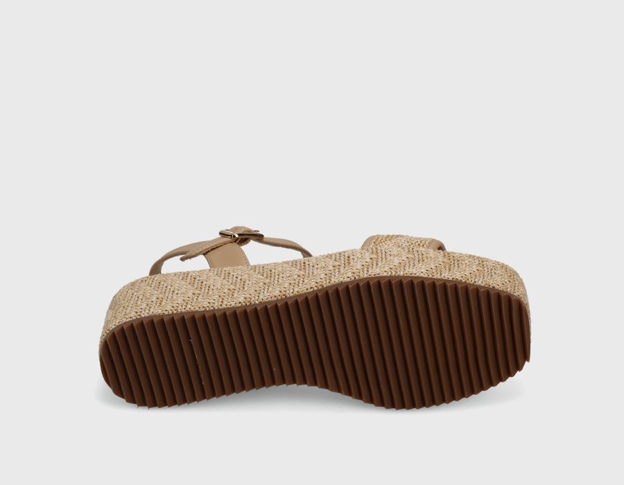 Brown sandal with textured sole on a light gray background