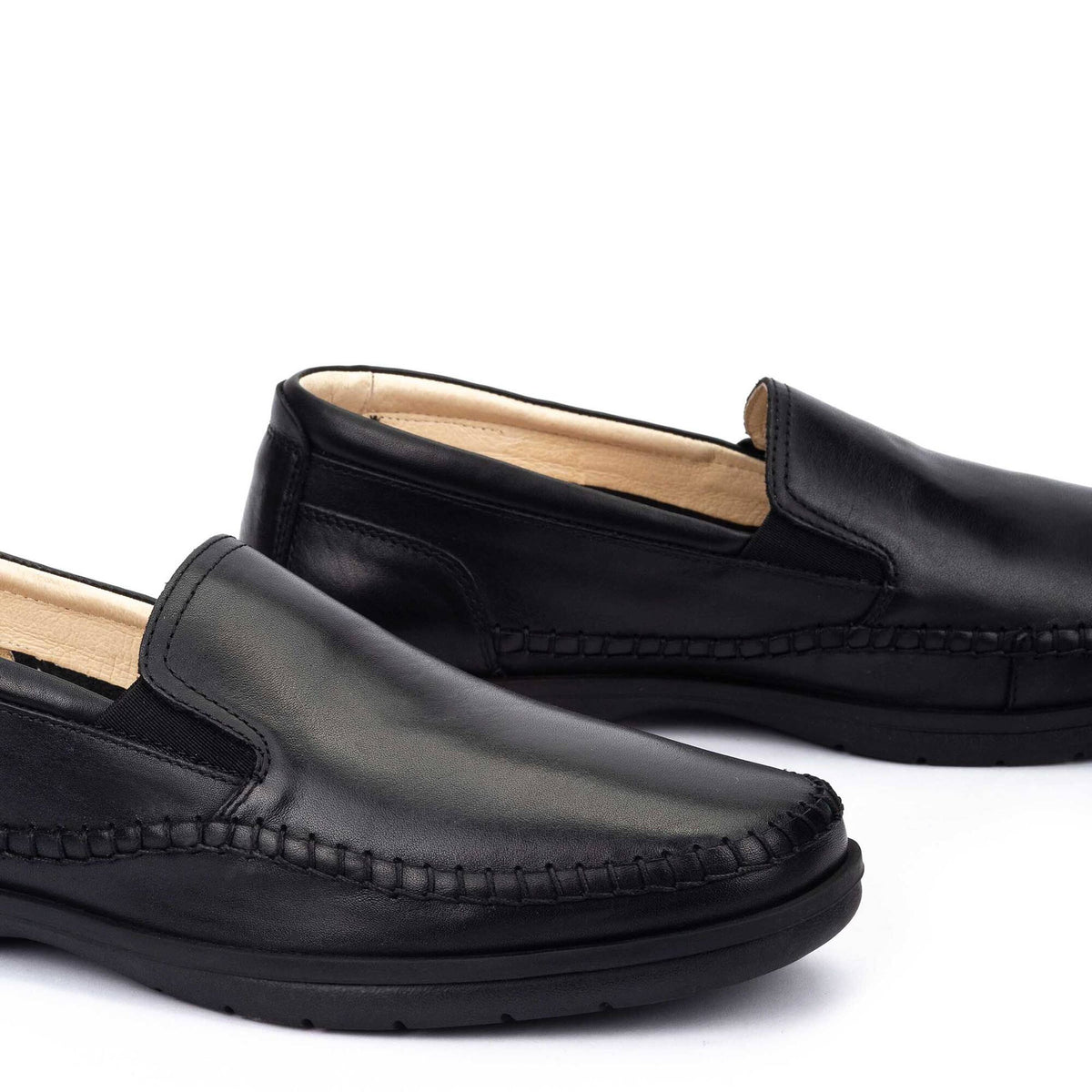 Pair of black leather loafers on a white background