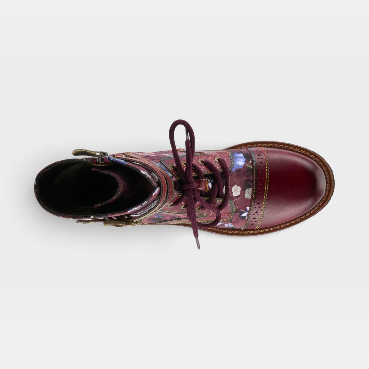 A single lace-up ankle boot shown from a top-down view on a light gray background. The boot features a glossy deep burgundy leather toe cap and heel, a floral brogue patterned midfoot section, and dark burgundy laces.