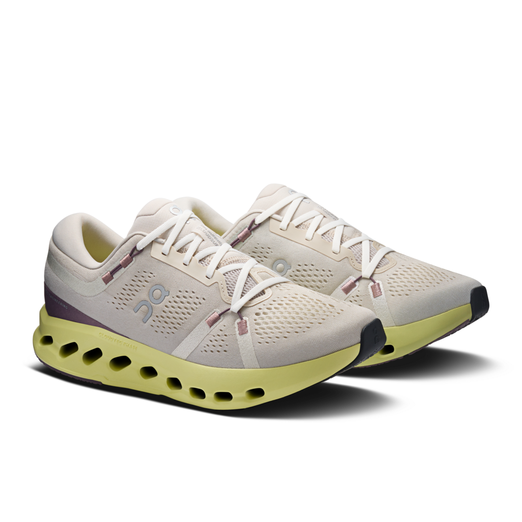 Pair of running shoes with a white and green design on a transparent background