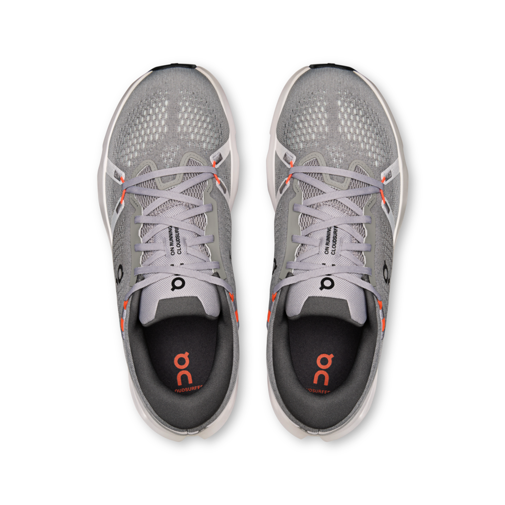 A pair of gray running shoes shown from a top-down view on a plain white background. The shoes feature gray mesh uppers, gray laces, a black and gray heel counter, and small orange accents on the inner sole and around the laces.