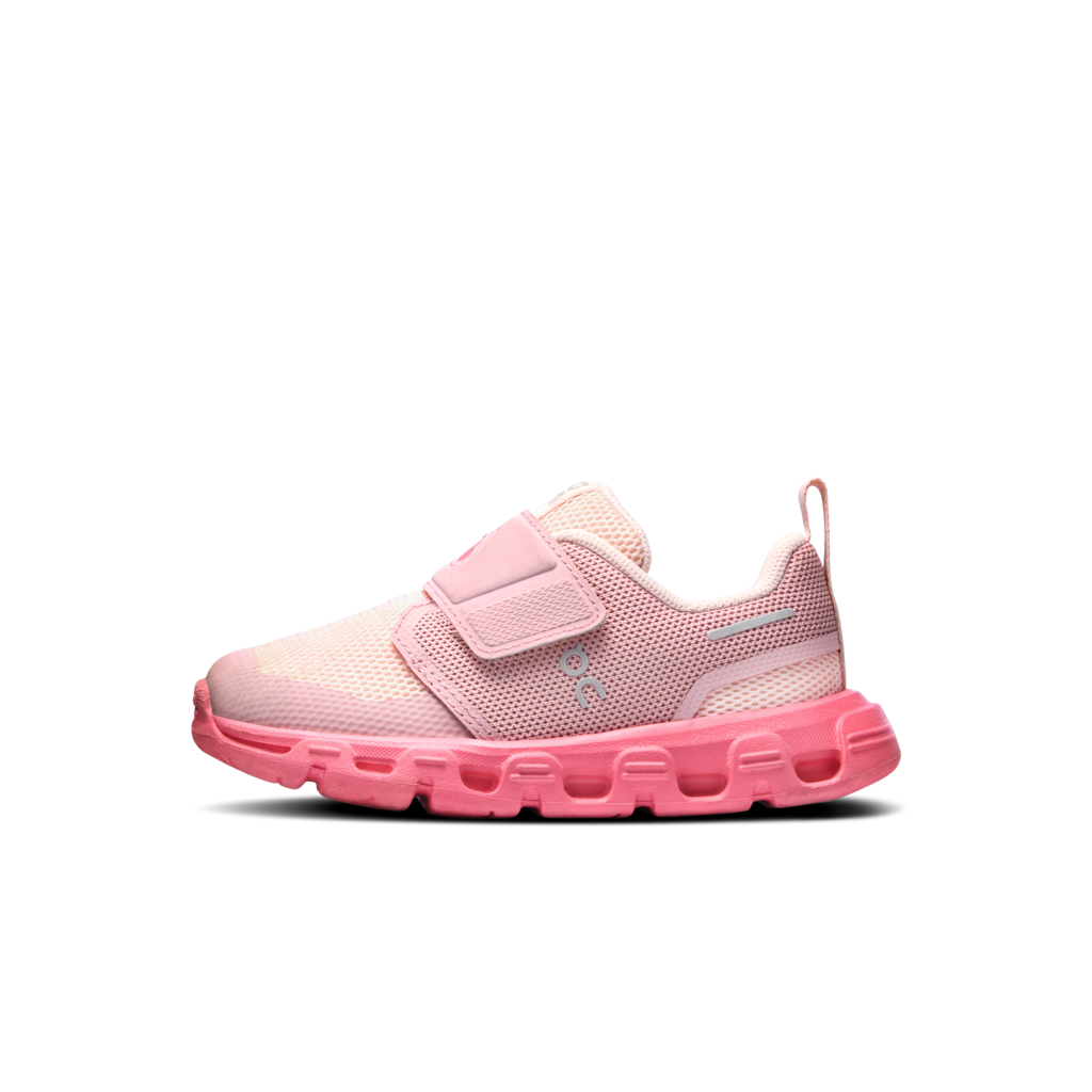 A children's slip-on sneaker in shades of pink, featuring a mesh upper, a hook-and-loop strap, and a chunky textured sole, shown against a plain white background.