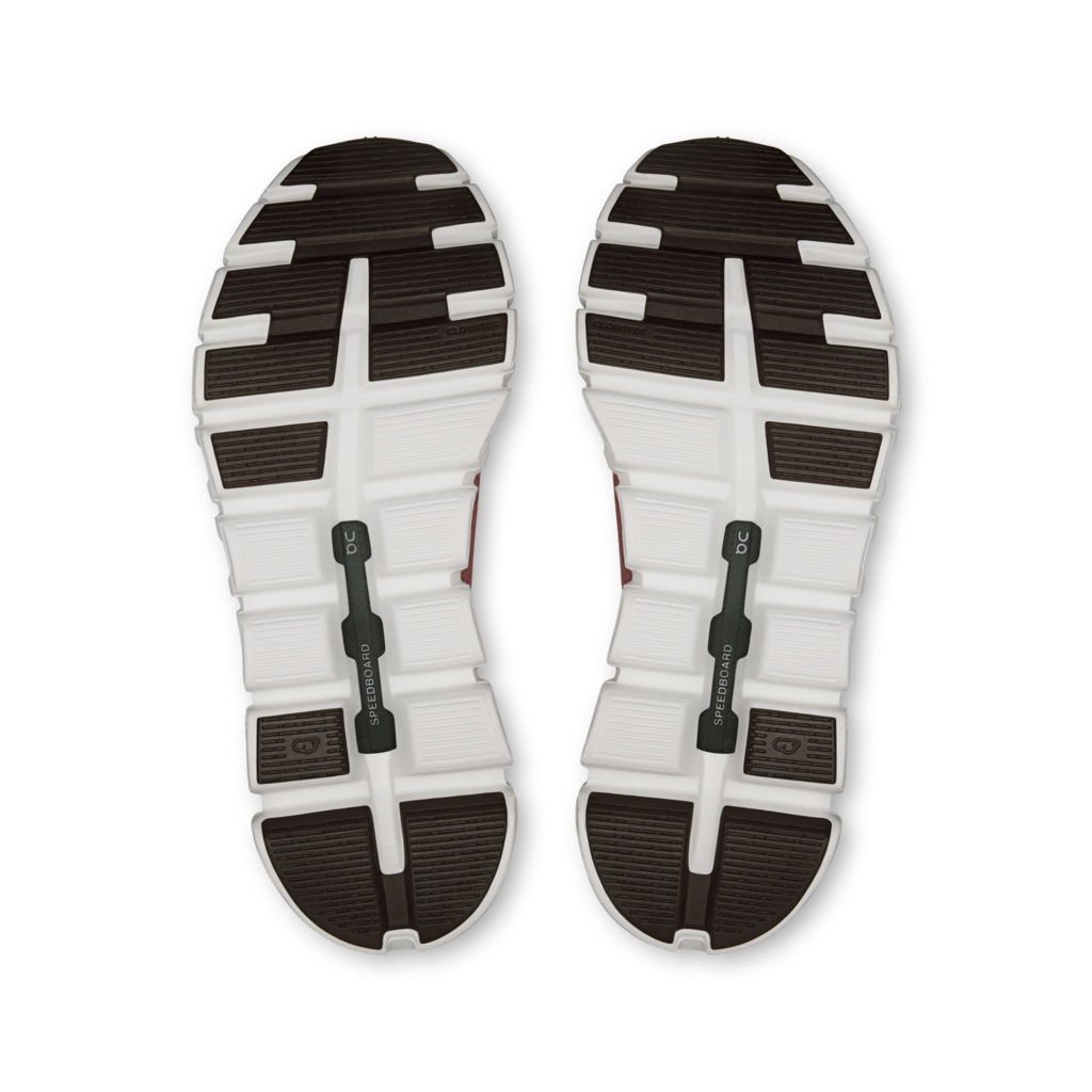 A pair of athletic shoes shown from the bottom, displaying their white and dark brown textured rubber soles against a plain white background.