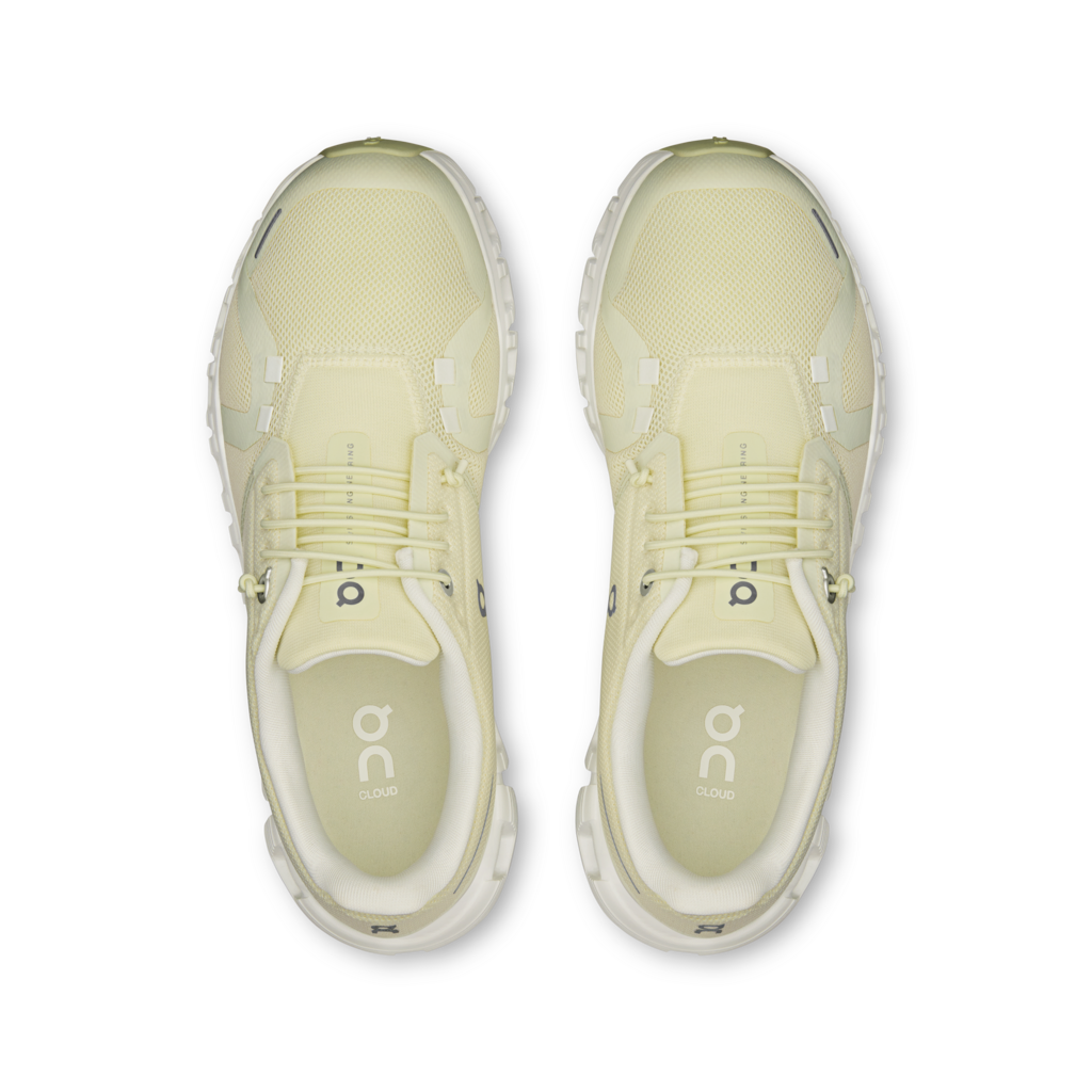 Pair of light yellow running shoes with 'on' branding on a white background