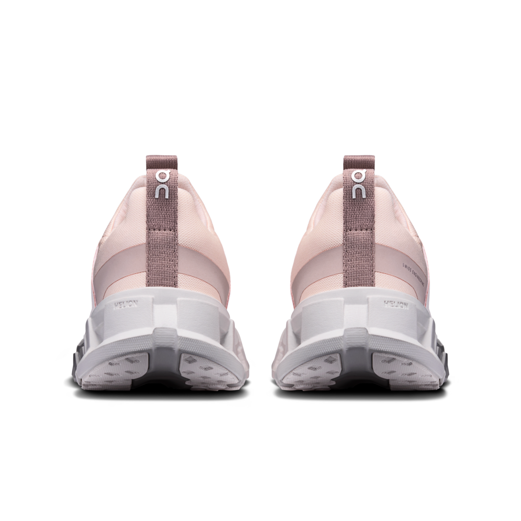 Pair of pink running shoes with a white sole on a white background