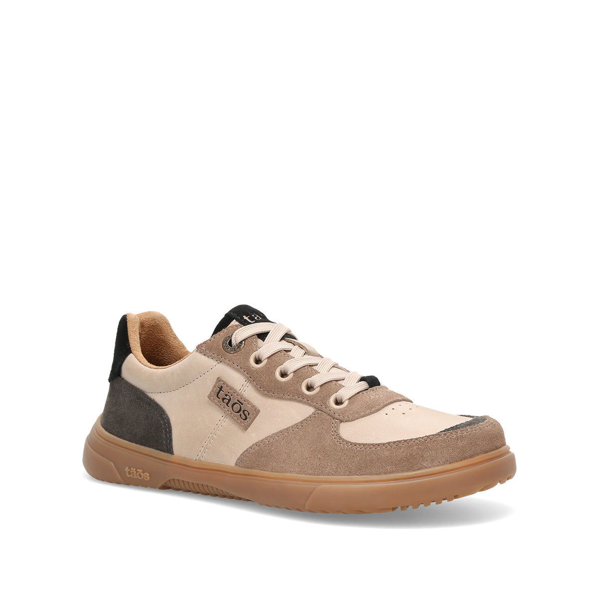 A Taos low-top sneaker in beige, taupe, and brown suede and mesh, featuring a gum sole and black accents on the tongue and heel.