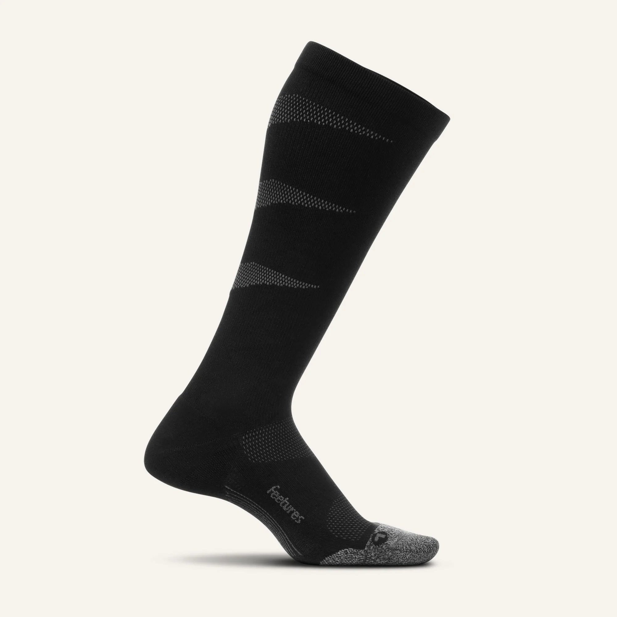 Black knee-high sock with patterned design on a light gray background