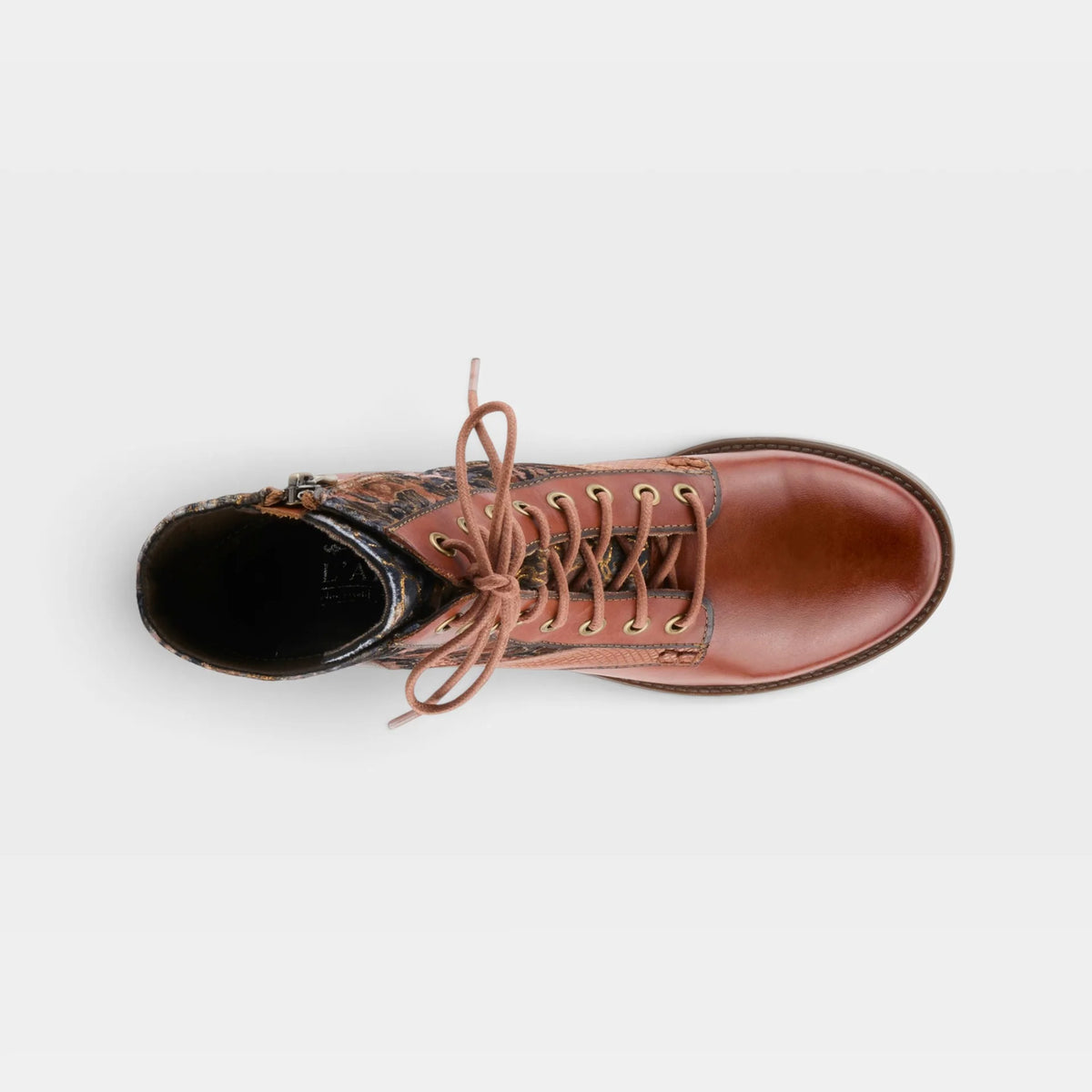 A top-down view of a brown leather lace-up boot with a patterned ankle section and tan laces, set against a plain light gray background.