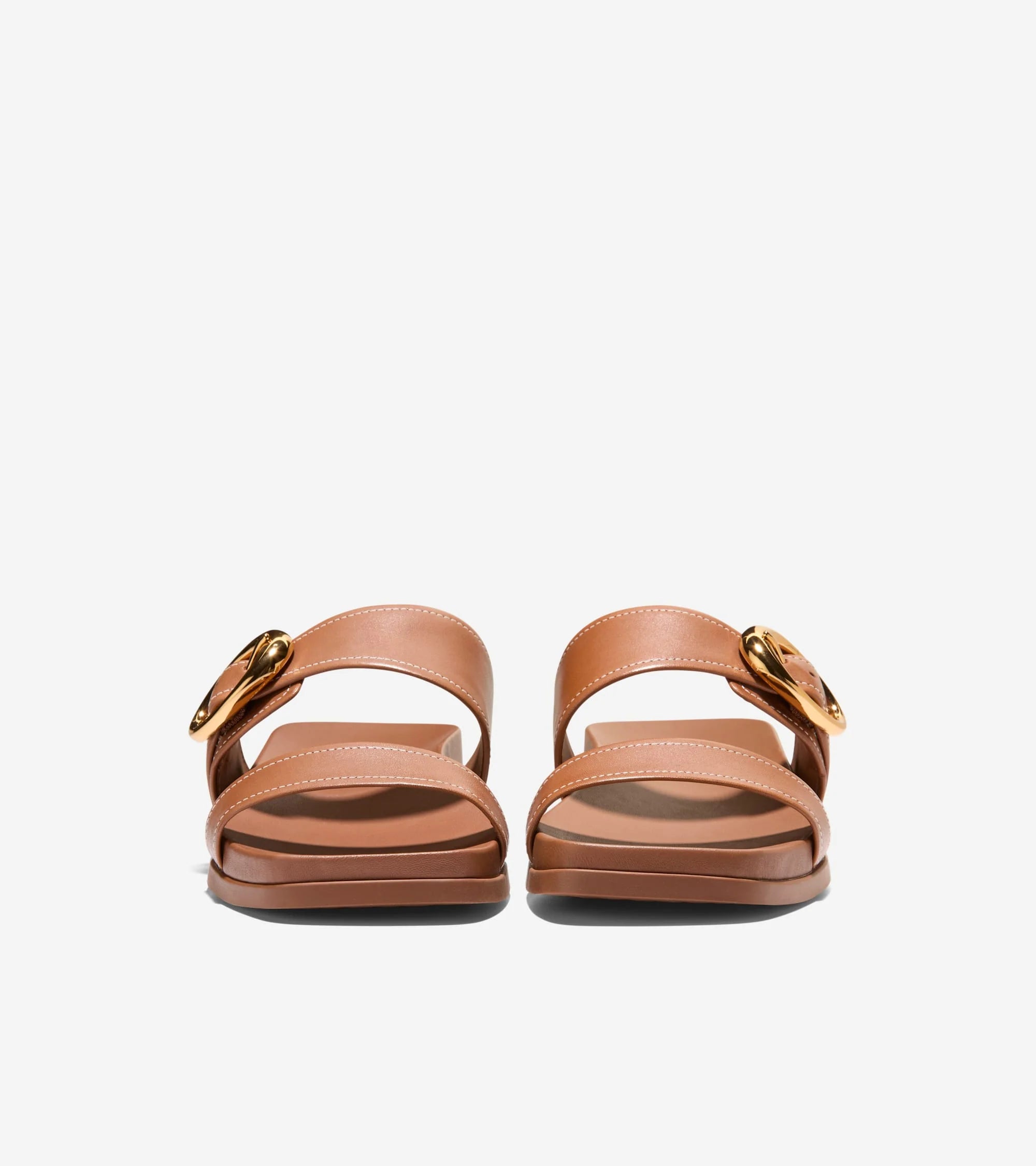 Pair of brown sandals with gold buckles on a white background