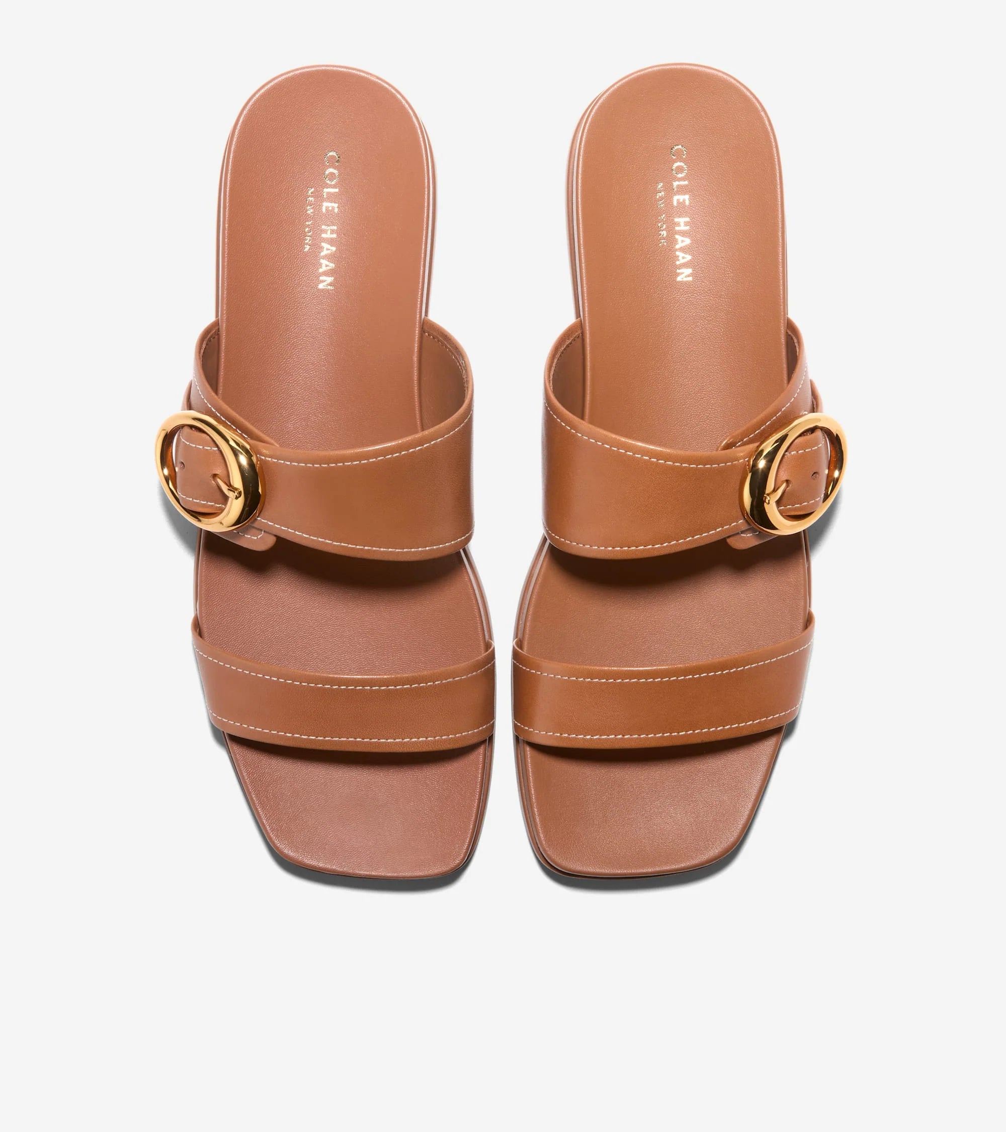 Brown sandals with gold buckle on a white background